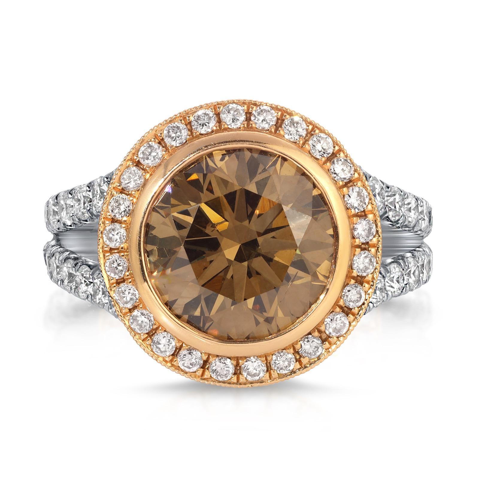 This enchanting handcrafted ring showcases a mesmerizing 4.02 carat champagne diamond SI1, beautifully encircled by a halo of round cut diamonds G-H/ VS1/VS2. The stunning center stone is mounted on 18K rose gold and continues it's charm by a pavé