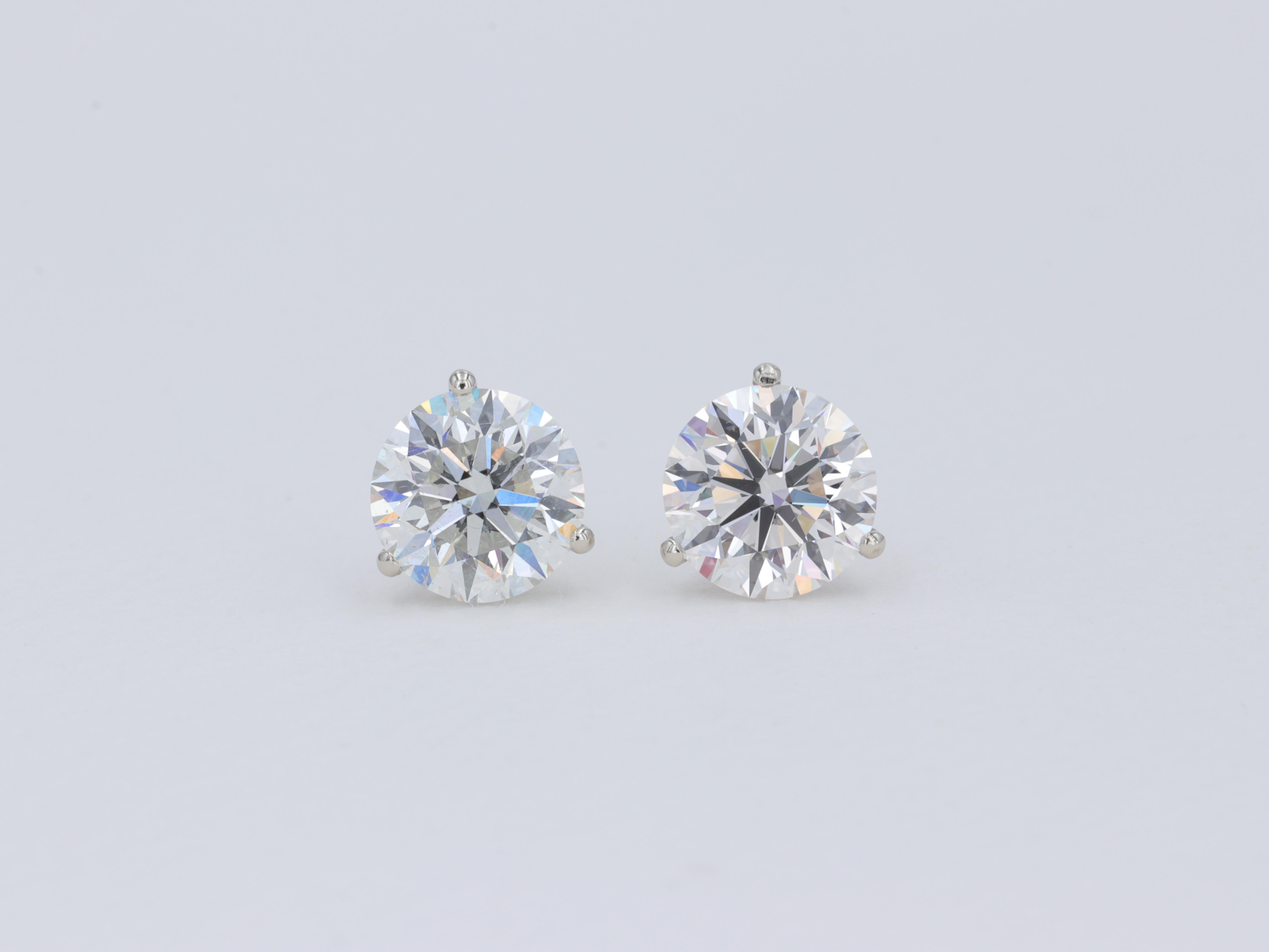An fine pair of diamond stud earrings featuring a 2.00 carat I color SI1 clarity triple excellent cut round brilliant diamond as graded by the Gemological Institute of America as well as a 2.02 carat H color SI2 clarity triple excellent cut round
