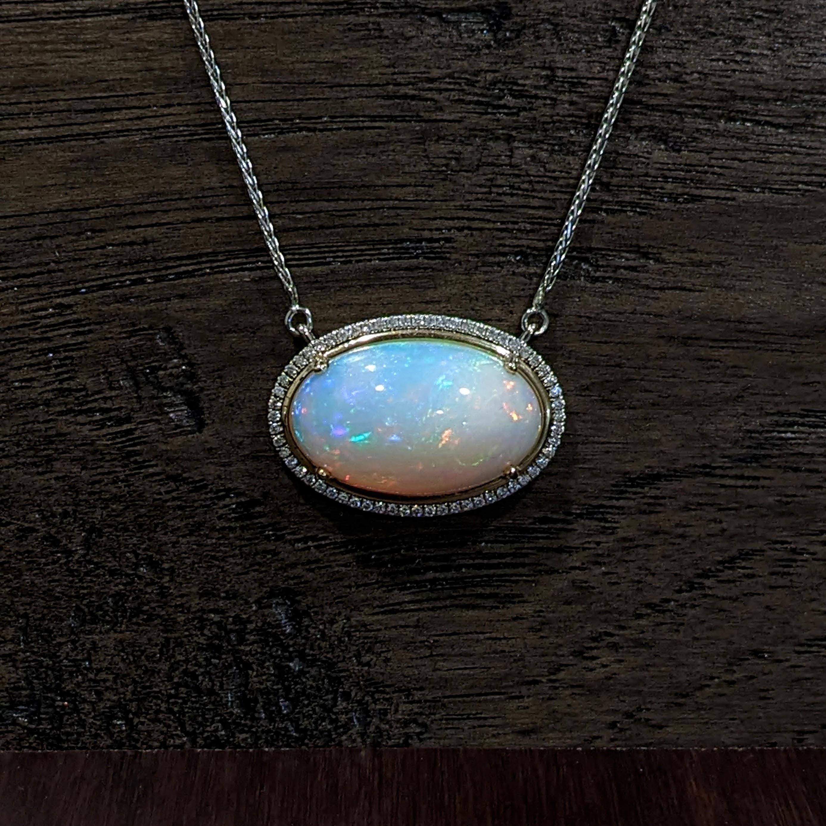 This gorgeous large Ethiopian Opal exhibits exquisite play of fire. It is set east west in a 14k dual tone yellow and white gold pendant setting with a natural diamond halo and attached 14k white gold chain.

Perfect for gifts, anniversaries, or any