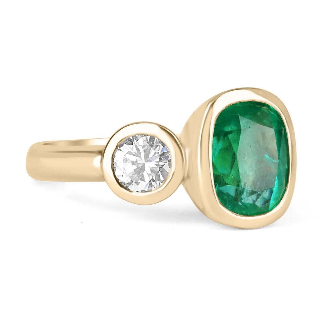 A classic Colombian emerald and diamond three-stone ring. Dexterously crafted in gleaming 18K gold this ring features a natural Colombian emerald-cushion cut from the famous Muzo mines. Set in a secure bezel setting, this extraordinary emerald has a