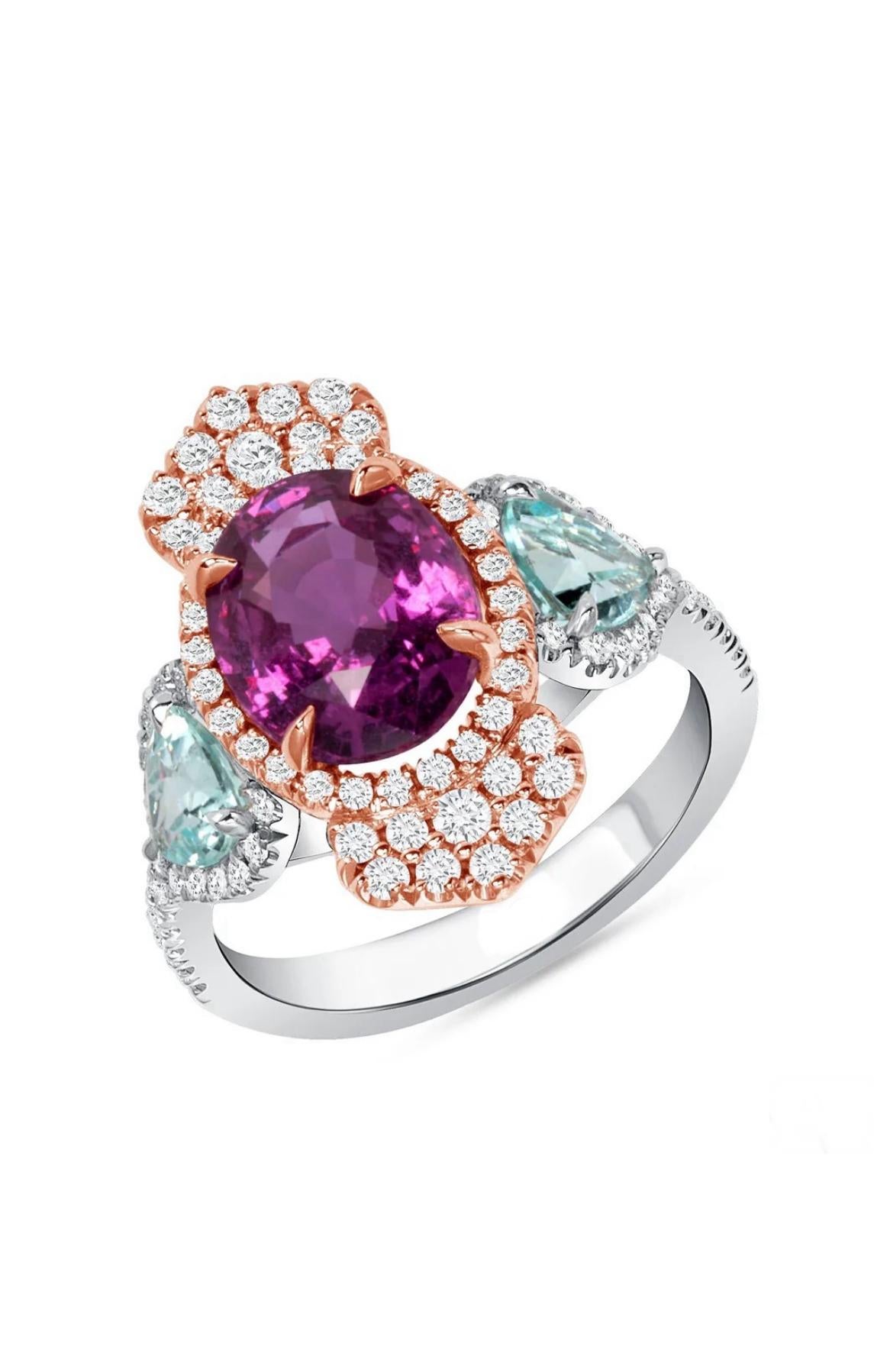 A 4.03ct, Boysenberry Sapphire from Sri Lanka is set with two 0.82ct Paraiba Tourmalines from Mozambique, accented by white diamonds totaling 0.56cts in this beauteous 18K white with rose gold ring. The boysenberry Sapphire is GIA certified, taking