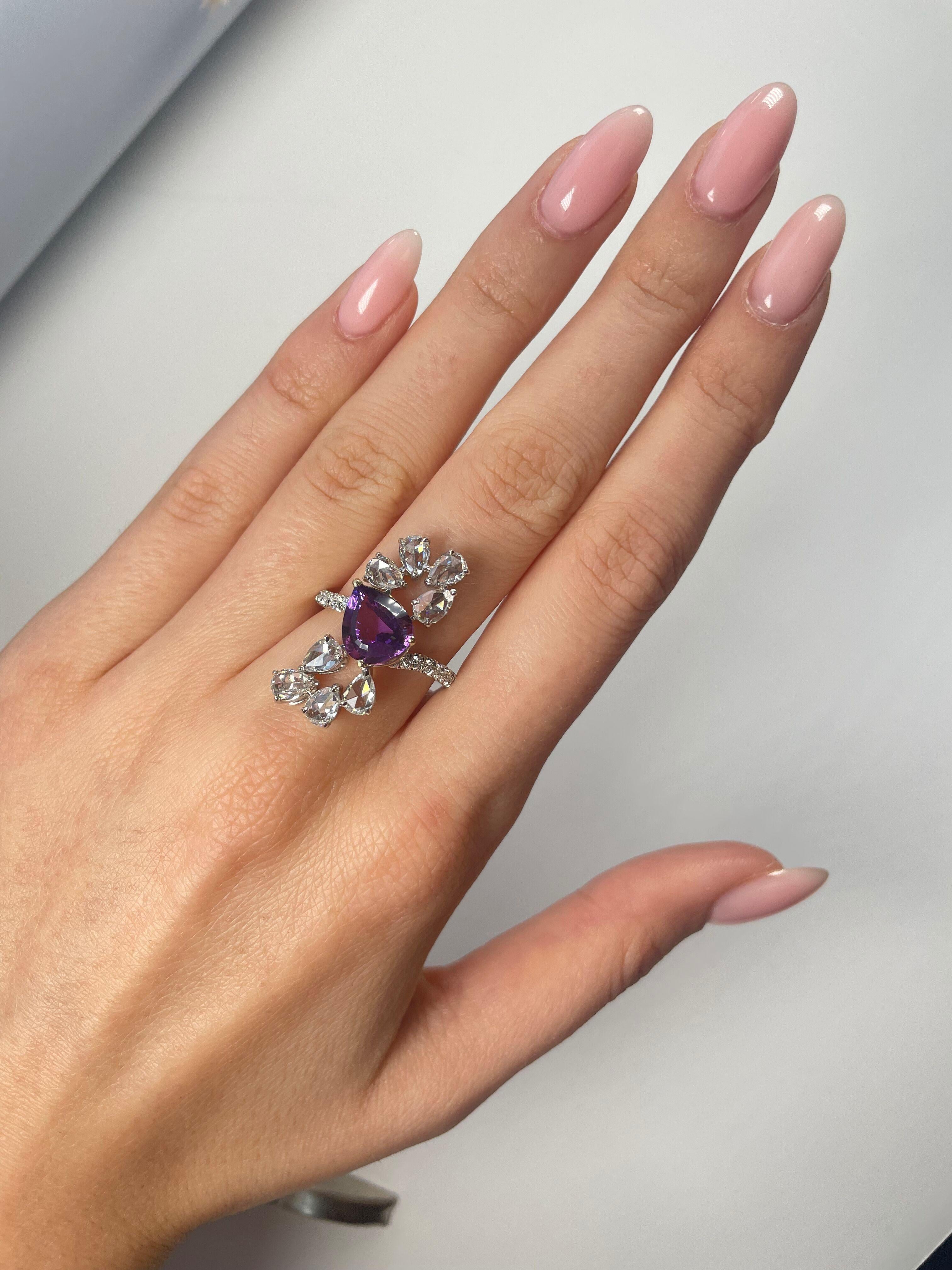 A mesmerizing in its brilliantly catching tone 2.07 Carat Pear Shaped Purple Amethyst Cocktail Ring set in a floral motif. Accentuated with 8 rose cut, pear-shaped white diamonds weighing approximately 1.68 carat. This unique and feminine ring is