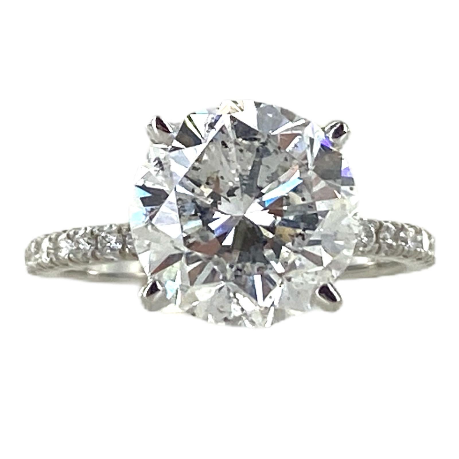 Stunning diamond engagement ring fashioned in 18 karat white gold. The round brilliant cut diamond weighs 4.04 carats and is graded F color and I1 clarity by the GIA. The white gold mounting features 16 round brilliant cut diamonds weighing .20