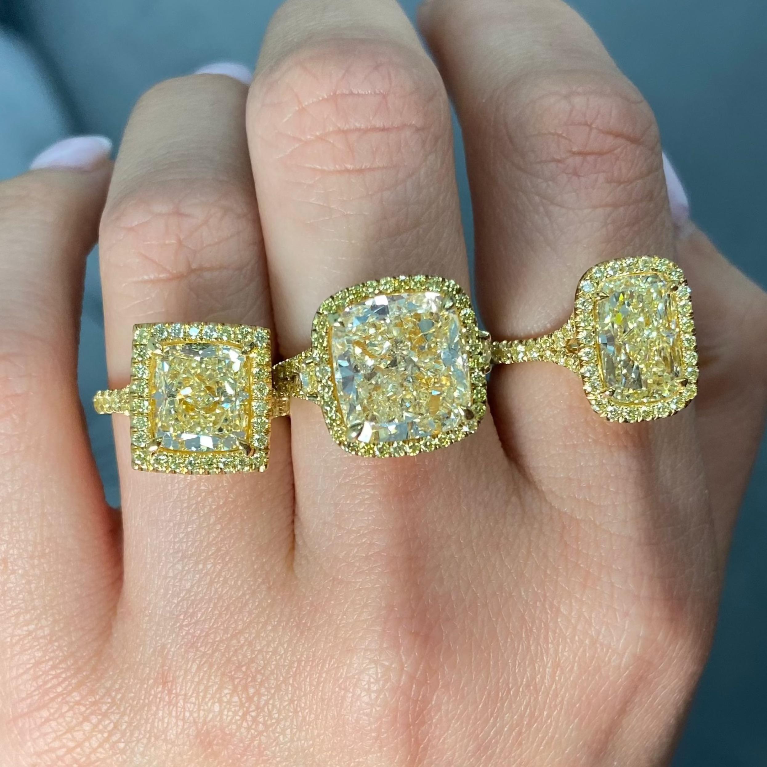 This stunning 4.04 carat light yellow diamond engagement ring showcases a beautifully elongated cushion cut in the U-V color range, offering a soft golden hue with eye-catching brilliance. With SI1 clarity, the center stone radiates warmth and