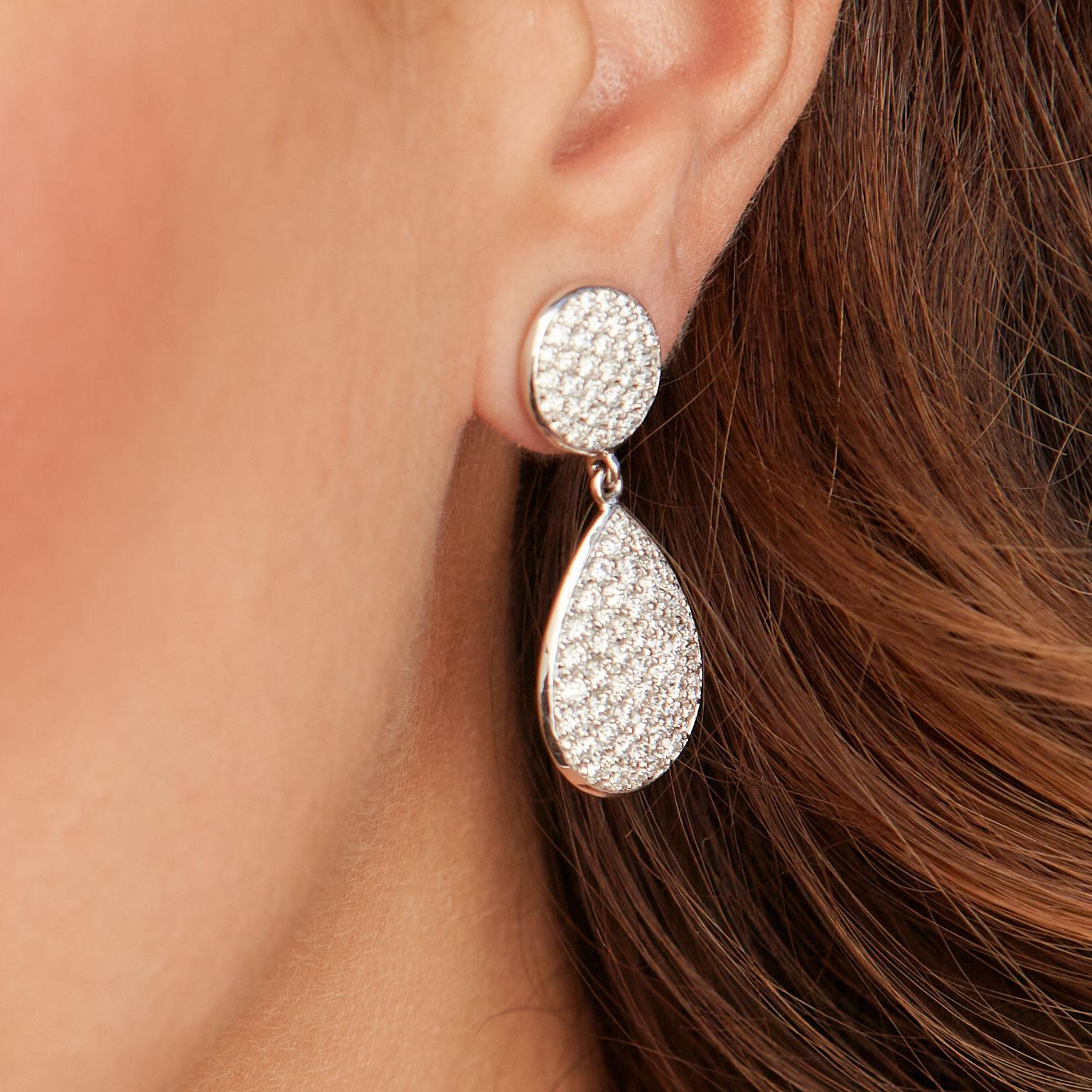 Diamond Pave Drop Earrings 4.05 Carat 18 Karat White Gold Earrings

These glamourous 14 karat white gold earrings featuring a total weight of 4.05 carat of diamond pave are set in a round and pear shape. 
The top, round portion encompassing the bail