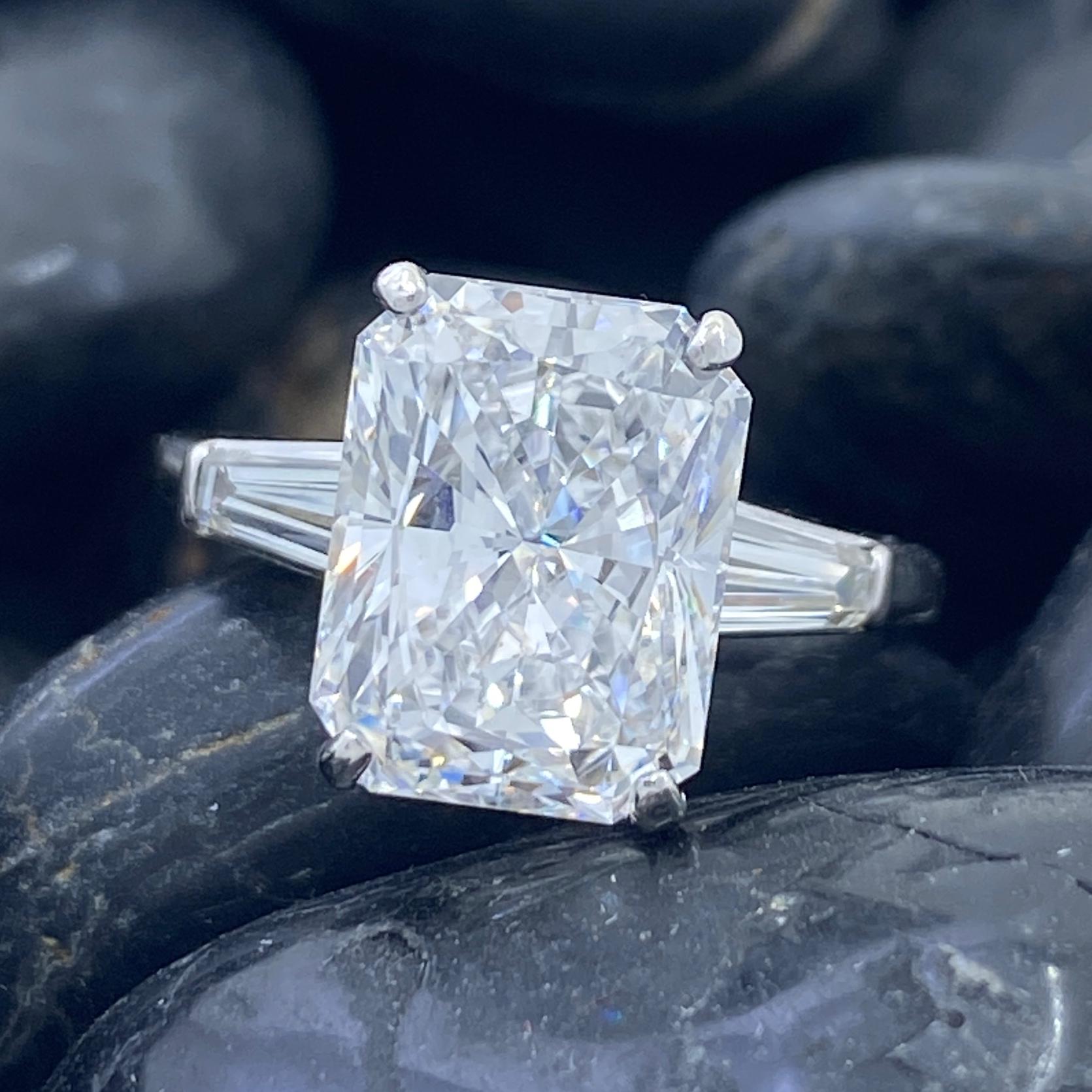 This magnificent ring features a nearly perfect, Radiant-cut white diamond, GIA-certified as VVS1 clarity and E color -- nearly flawless and nearly colorless.  In other words, nearly perfect!

We love the combination of a vintage setting with a