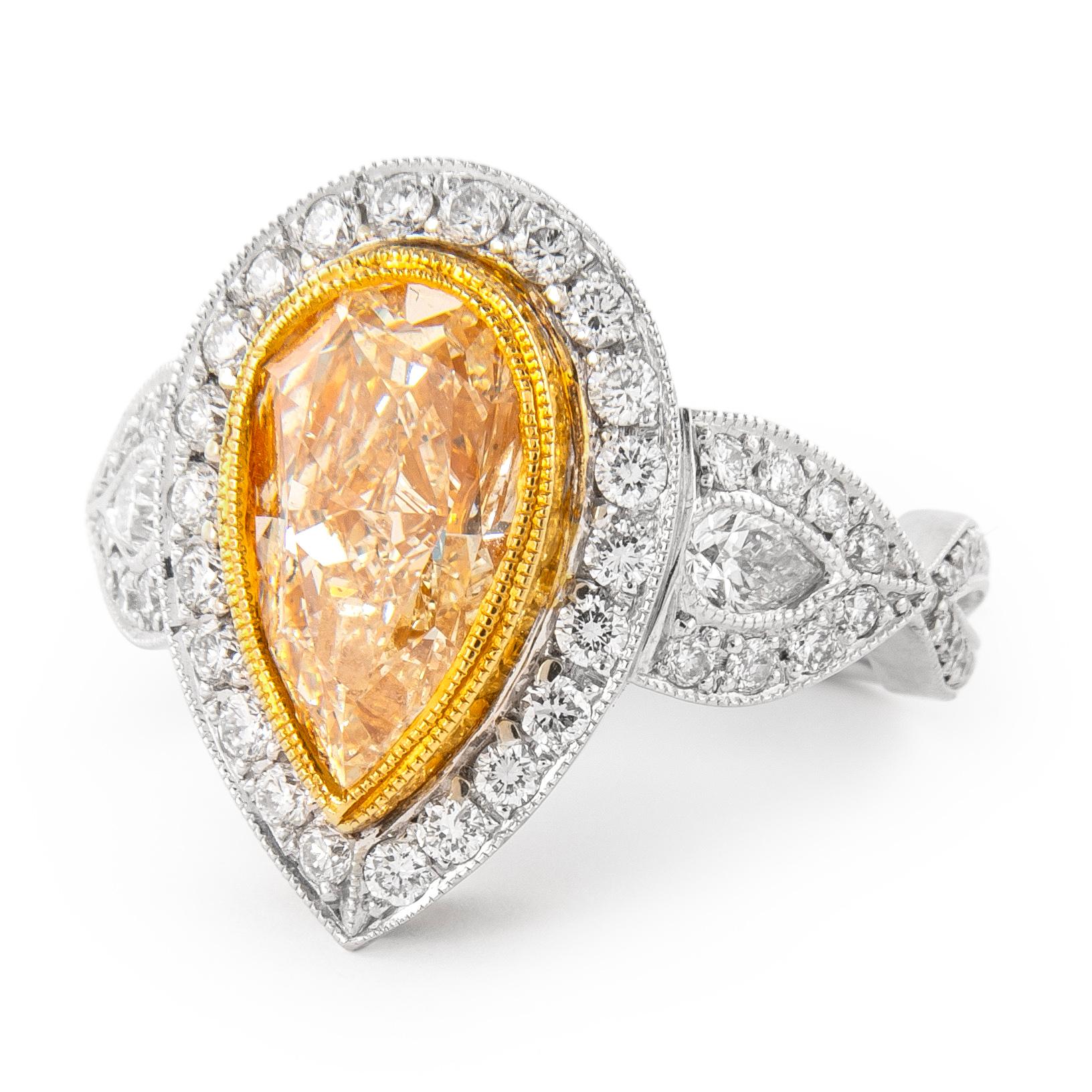 Beautiful pear fancy yellow diamond three-stone with halo ring, two-tone 18k yellow and white gold with milgrain work. High jewelry by Alexander Beverly Hills.
6.56 carats total diamond weight.
4.06 carat pear shape, approximately Fancy Yellow color