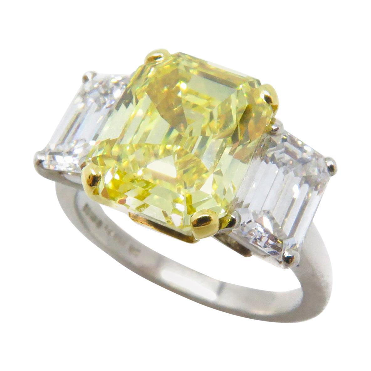 4.07 Carat Fancy Vivid Emerald Cut Yellow Diamond Three Stone Engagement Ring For Sale