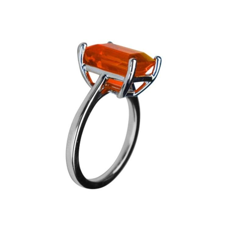 Elegant & finely detailed Solitaire Cocktail Ring, set with a securely nestled  4.07 Carat Intense Orange Emerald-cut Fire Opal, clarity: internally flawless (IF); dimensions: 12.0mm x 9.0mm. Hand crafted in 18 Karat White Gold. The ring epitomizes