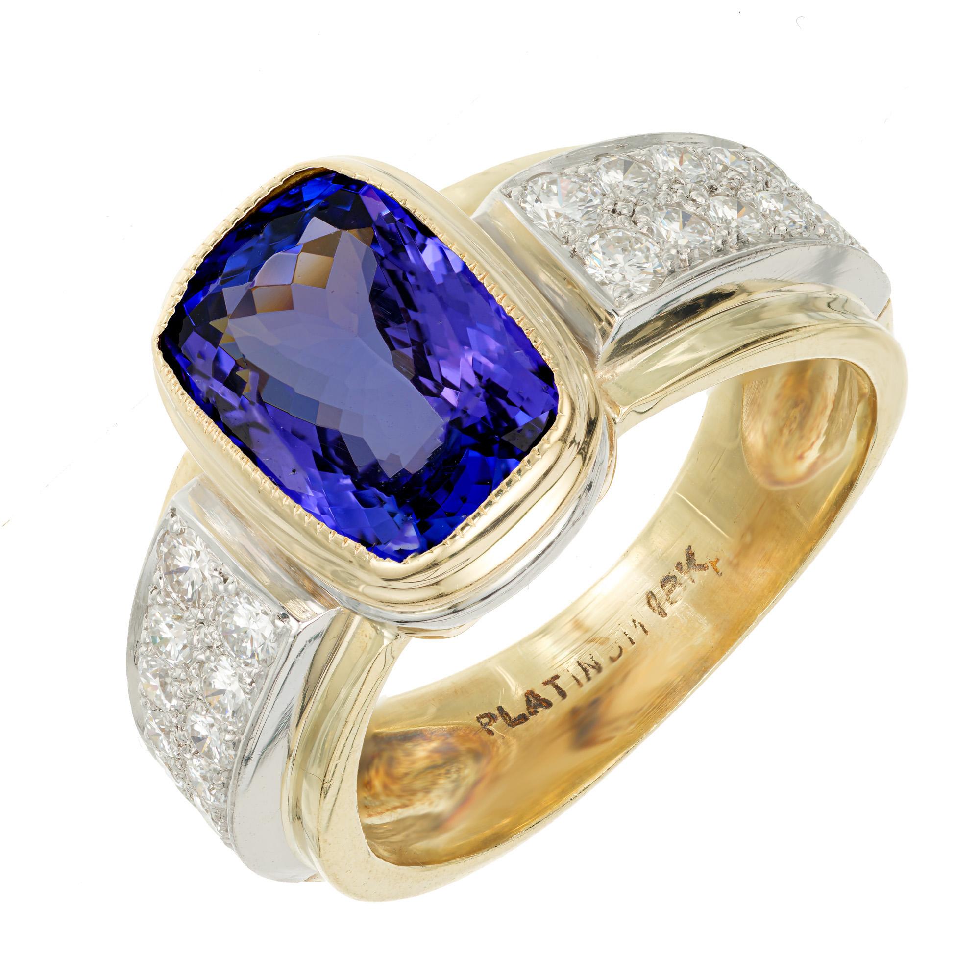 1970's Tanzanite and diamond ring. 4.08ct cushion cut bezel set Tanzanite center stone placed in an 18k yellow gold and platinum ring. Accented with 28 round pave set diamonds which are set in platinum. The Tanzanite also has a ring of Platinum