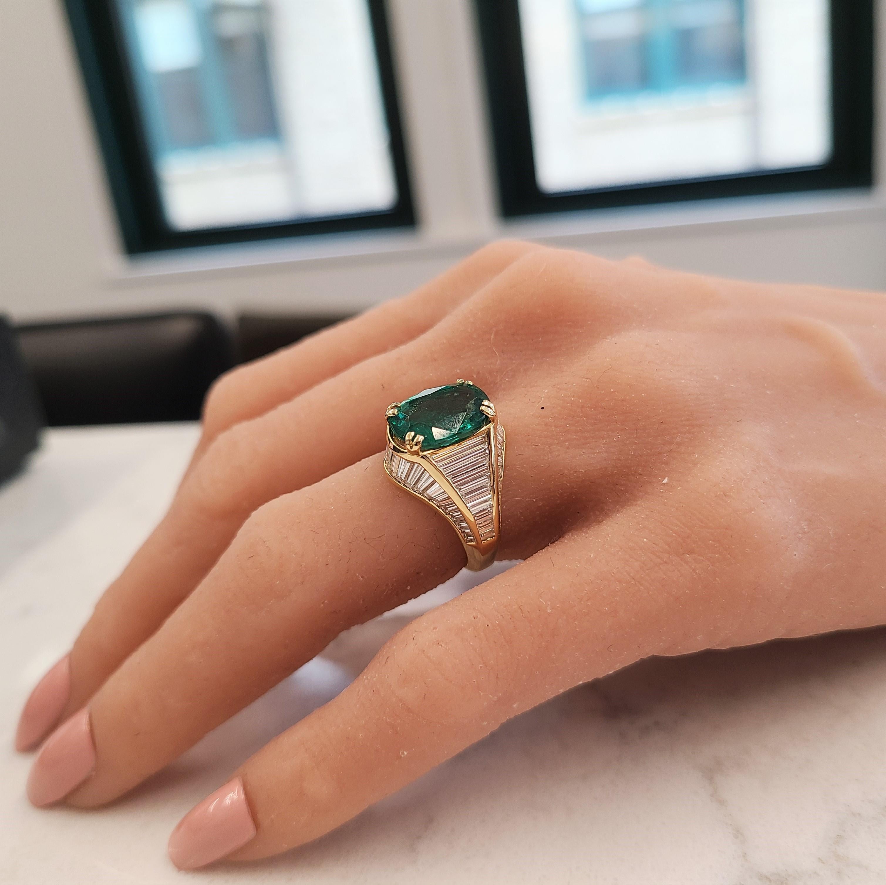 Designed in brightly polished 18 karat yellow gold, this gorgeous emerald and diamond ring features a prong set 4.08 carat emerald in the center that exhibits a deep green hue and is accompanied by an IGITL certification upon purchase. This emerald