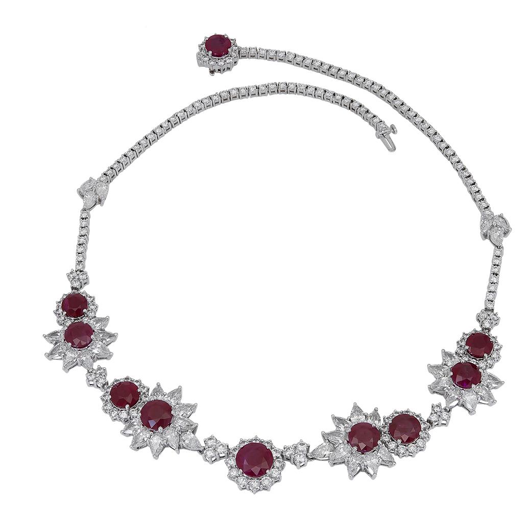 An important piece of jewelry featuring 40.89 carats of vibrant round rubies, set in a brilliant diamond halo consisting of pear shapes and rounds. Designed as a star-burst / floral motif. Made in 18k white gold. A magnificent necklace that has a