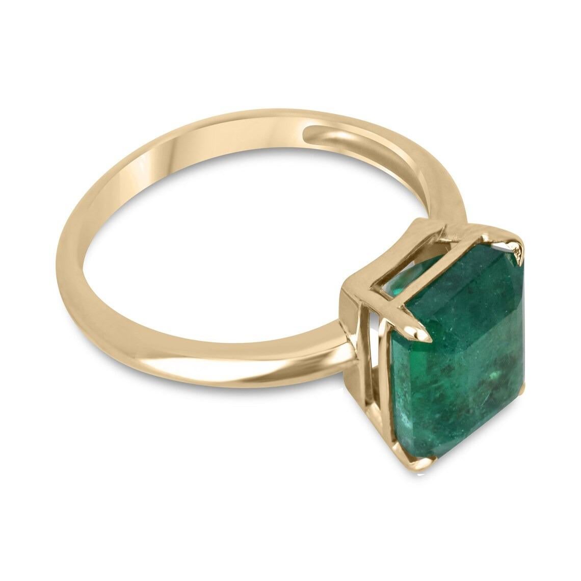This ring is not for the faint of heart! Displayed is a deep green emerald solitaire emerald-cut engagement ring in .fine 14K yellow gold. This gorgeous solitaire ring carries a full 4.08-carat emerald in a four-prong setting. The emerald has