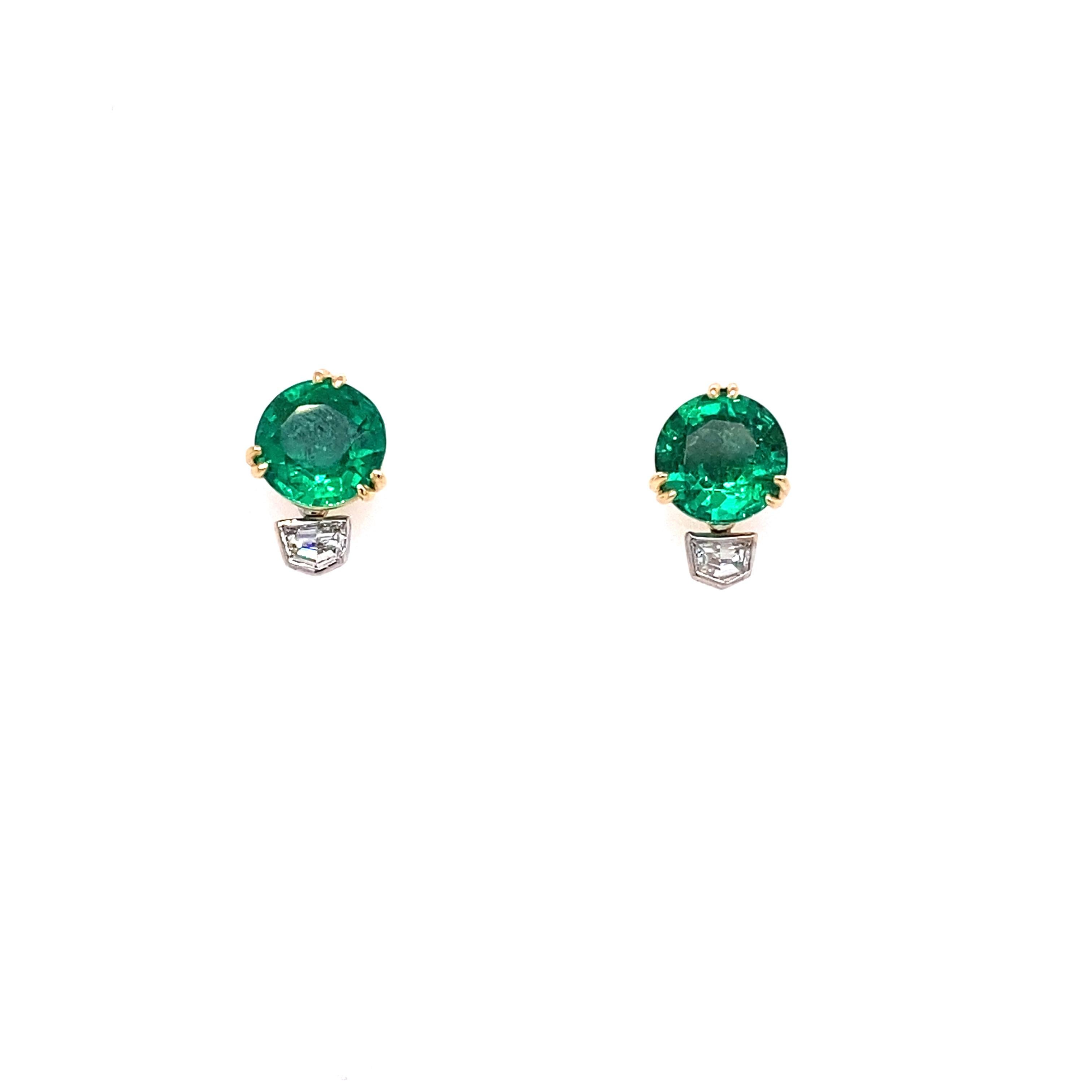 These stud earrings feature Zambian emeralds totaling 4.08 carats with a cadillac cut diamond that drops below and round diamonds along the gallery rail with a total weight of .47 carats.  Set in 18 karat yellow and white gold. Post Back.  
Weight: