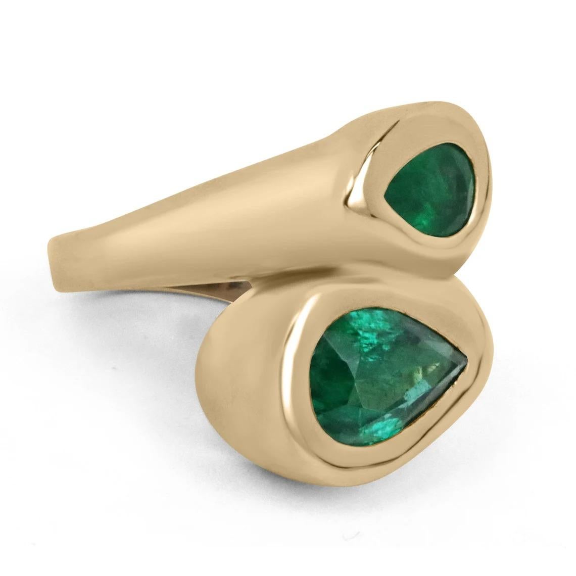 A fascinating, emerald dual bypass statement ring. This beauty features a total of 4.08-carats, of natural Zambian pear-cut emeralds with remarkable characteristics. Both gemstones display an enchanting dark green color, transparent clarity,