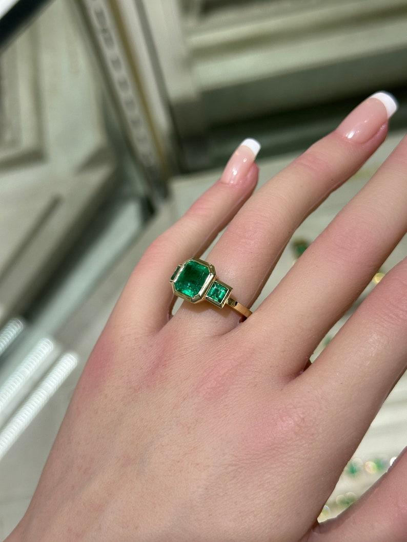 4.08tcw 14K Gold Asscher Cut Emerald Trilogy Ring, Princess Cut Accent, Bezel Se In New Condition For Sale In Jupiter, FL
