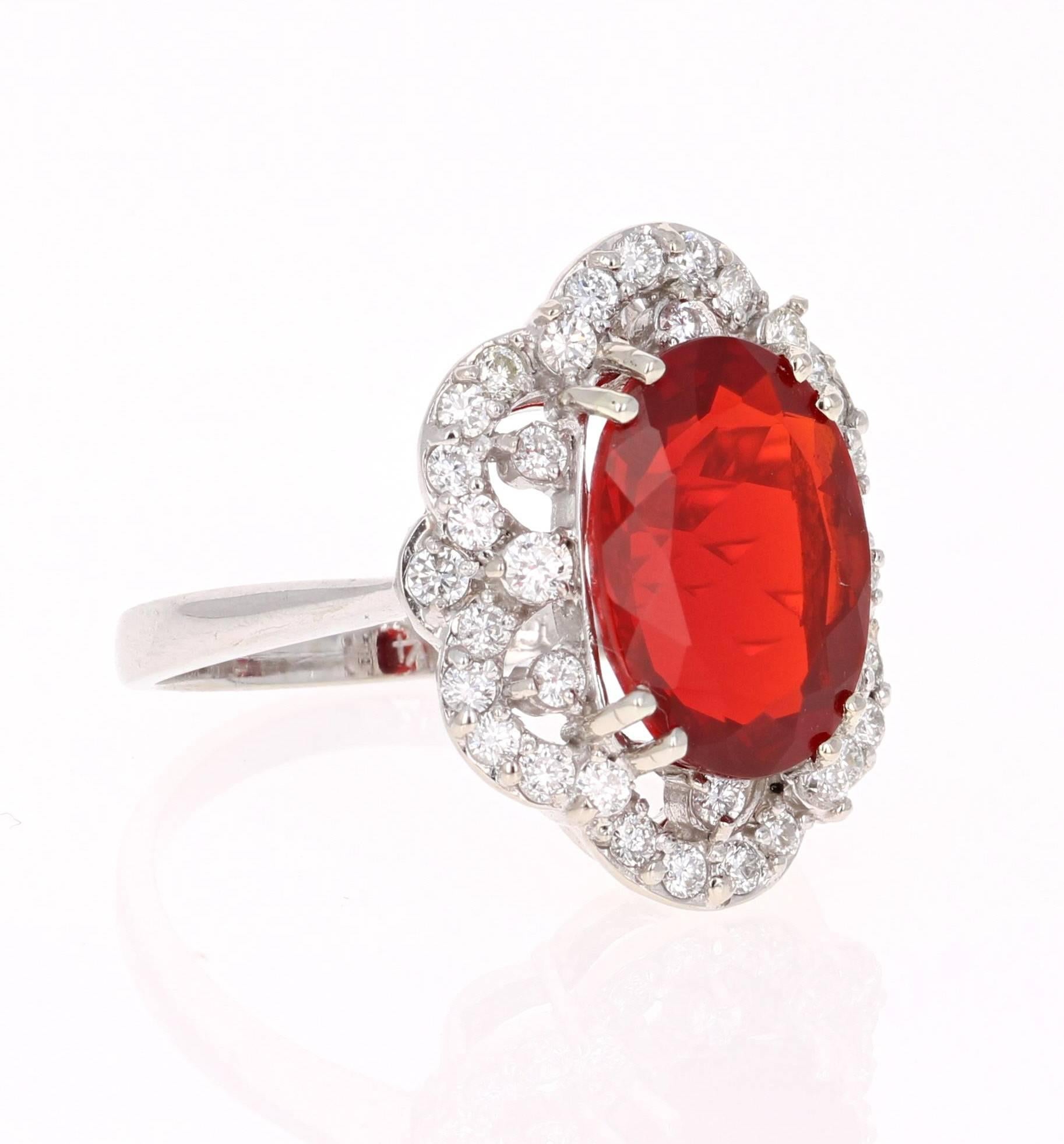 This bright and bold cocktail ring has a scintillating Oval Cut Fire Opal that weighs 3.45 carats and 36 Round Cut Diamonds that weigh 0.64 carats. The clarity and color of the diamonds are VS2-H.  The total carat weight of the ring is 4.09 carats.
