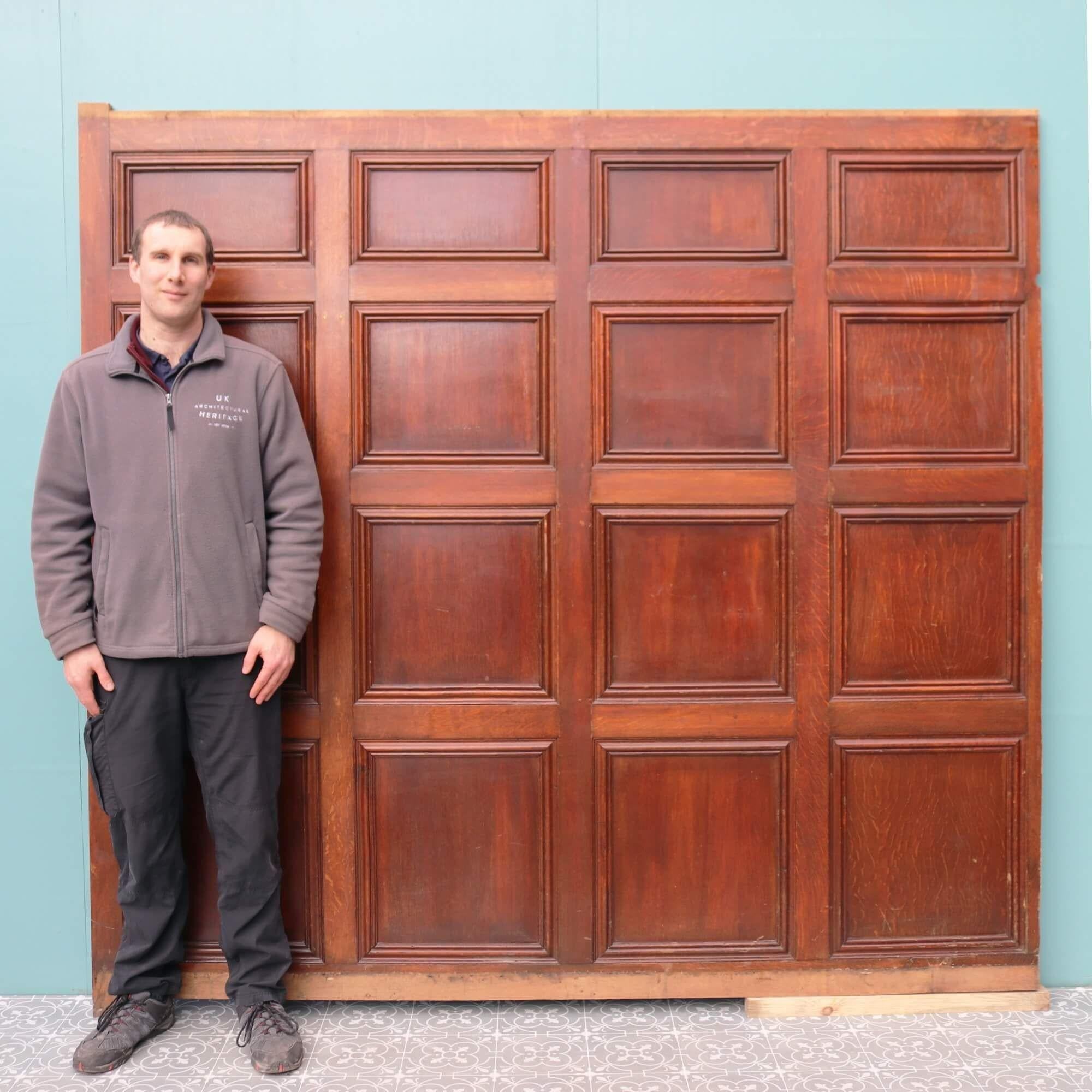 A long run of full height Victorian style wooden wall paneling with a rich dark oak finish dating from the early 1900s. Reclaimed from a property in Liverpool UK, this set of antique wall paneling comprises of 12 tall individual panels of varying
