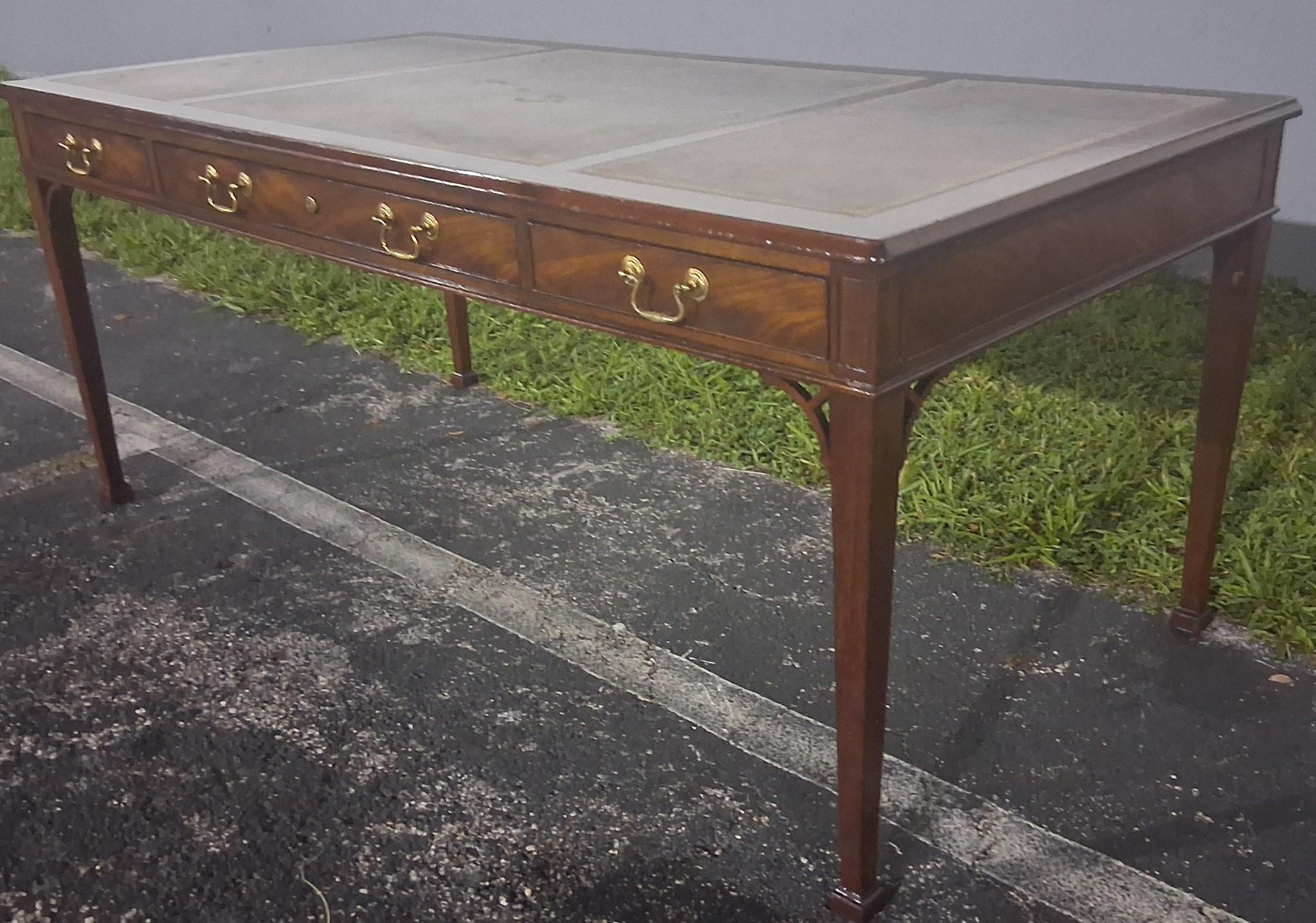 1940's Traditional style Executive Writing Desk by Baker Furniture Company. Carved walnut, green leather top. Brass hardware, 3 drawers. Baker Furniture Badge and 