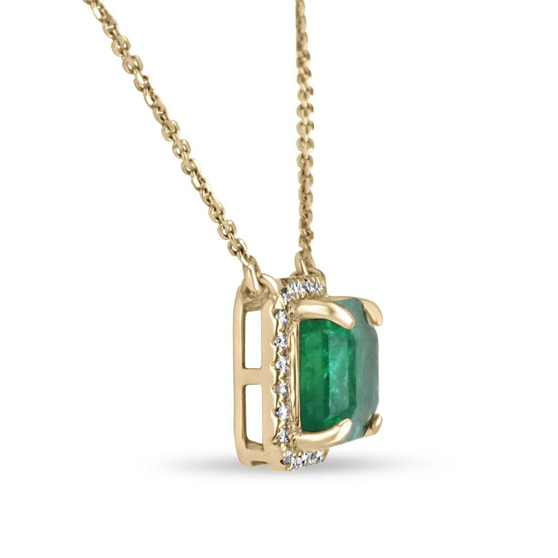 Featured here is a stunning statement size East to West rich bluish green emerald and round diamond halo necklace handmade in fine 14K yellow gold. Displayed is a lustrous, medium-rich green with very good transparency, accented by a simple secure