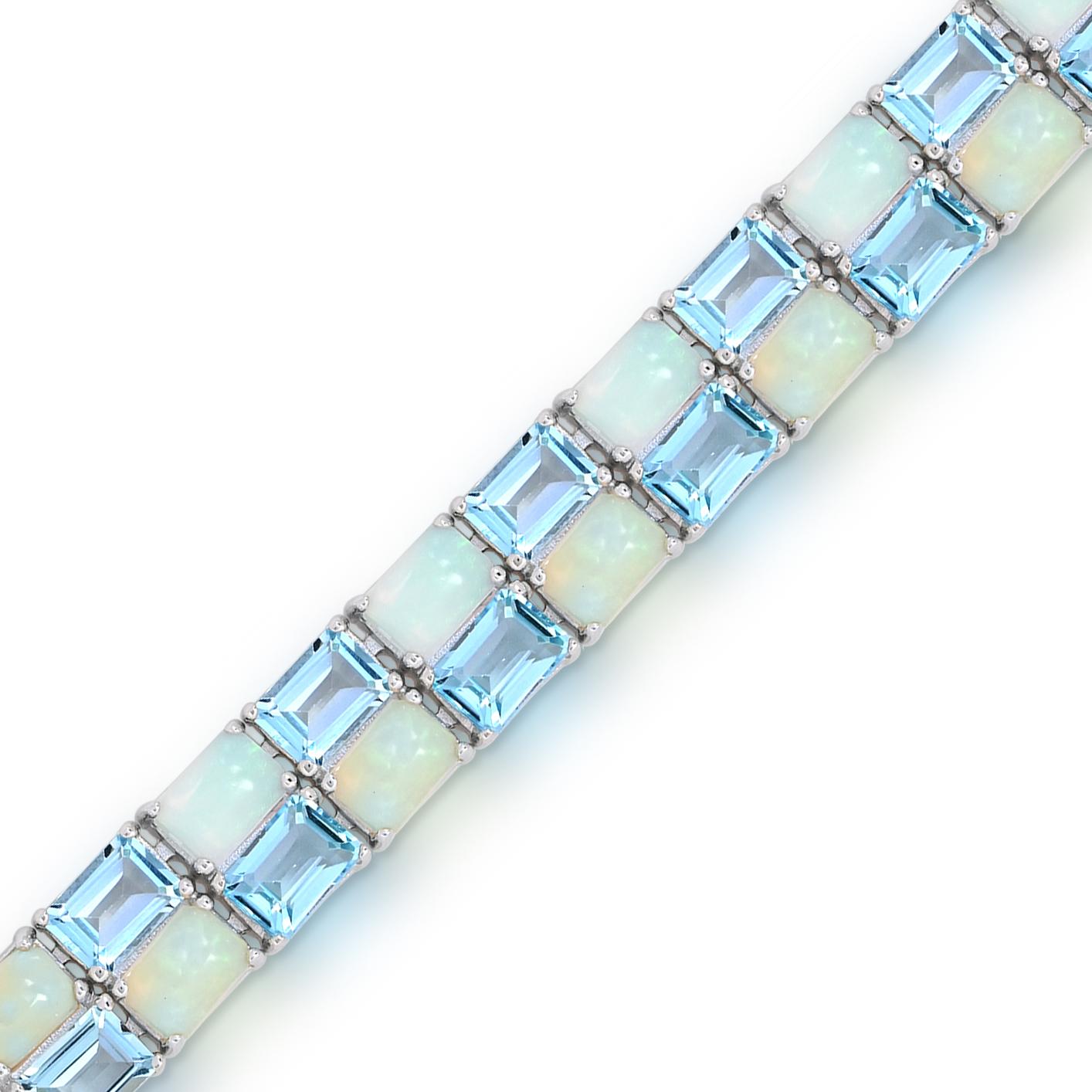 Ce magnifique bracelet présente 44 pièces de topaze bleue ciel brillante de taille émeraude et des pierres opales octogonales serties en alternance, créant ainsi un design visuellement captivant. Fabriqué avec précision et souci du détail, le