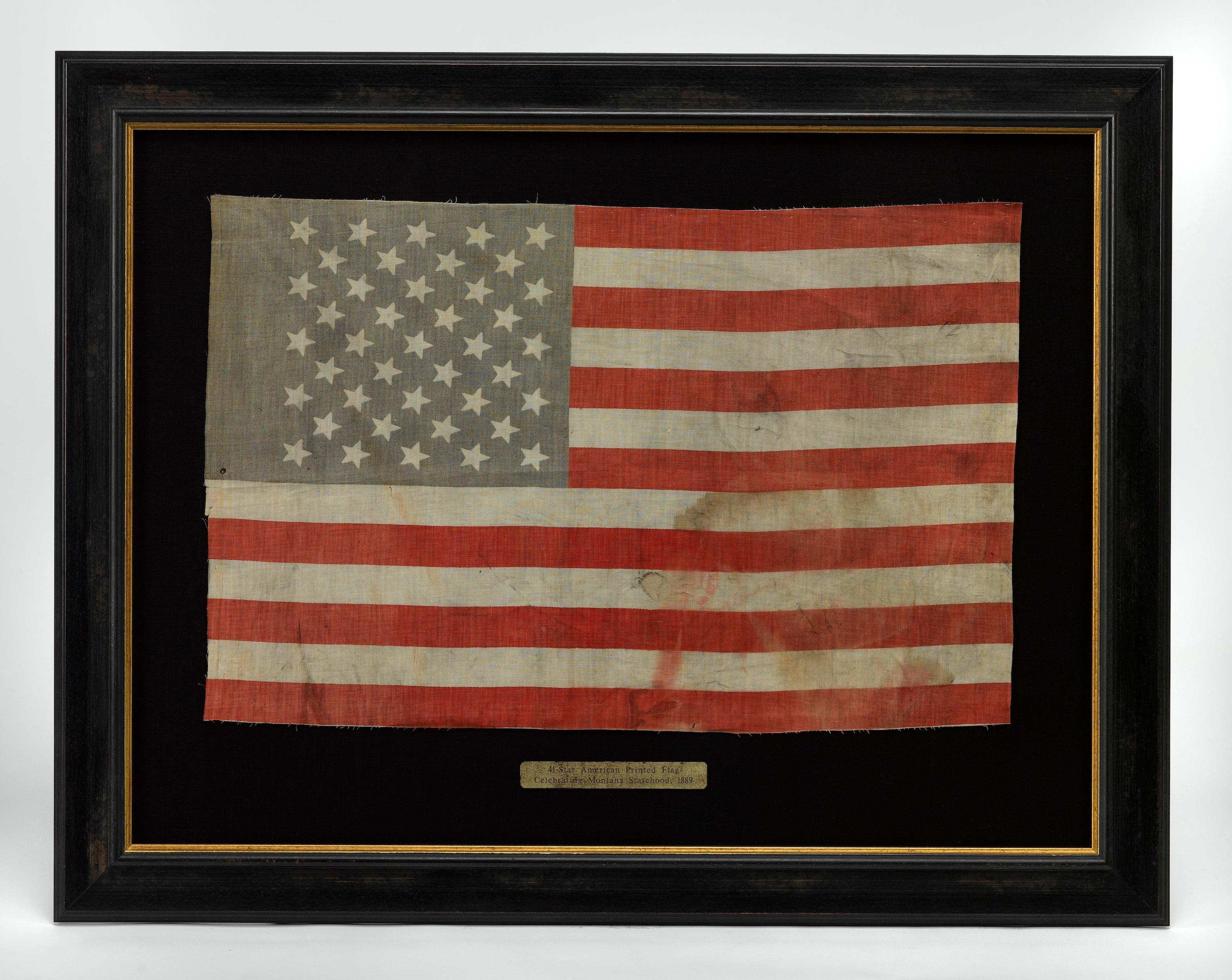 Presented is a very rare and attractively-sized 41-star flag waver, celebrating Montana statehood. The flag is printed on linen and dates to 1889. The blue canton is printed with 41 stars, arranged in 9 rows of alternating counts of 5 and 4 stars.