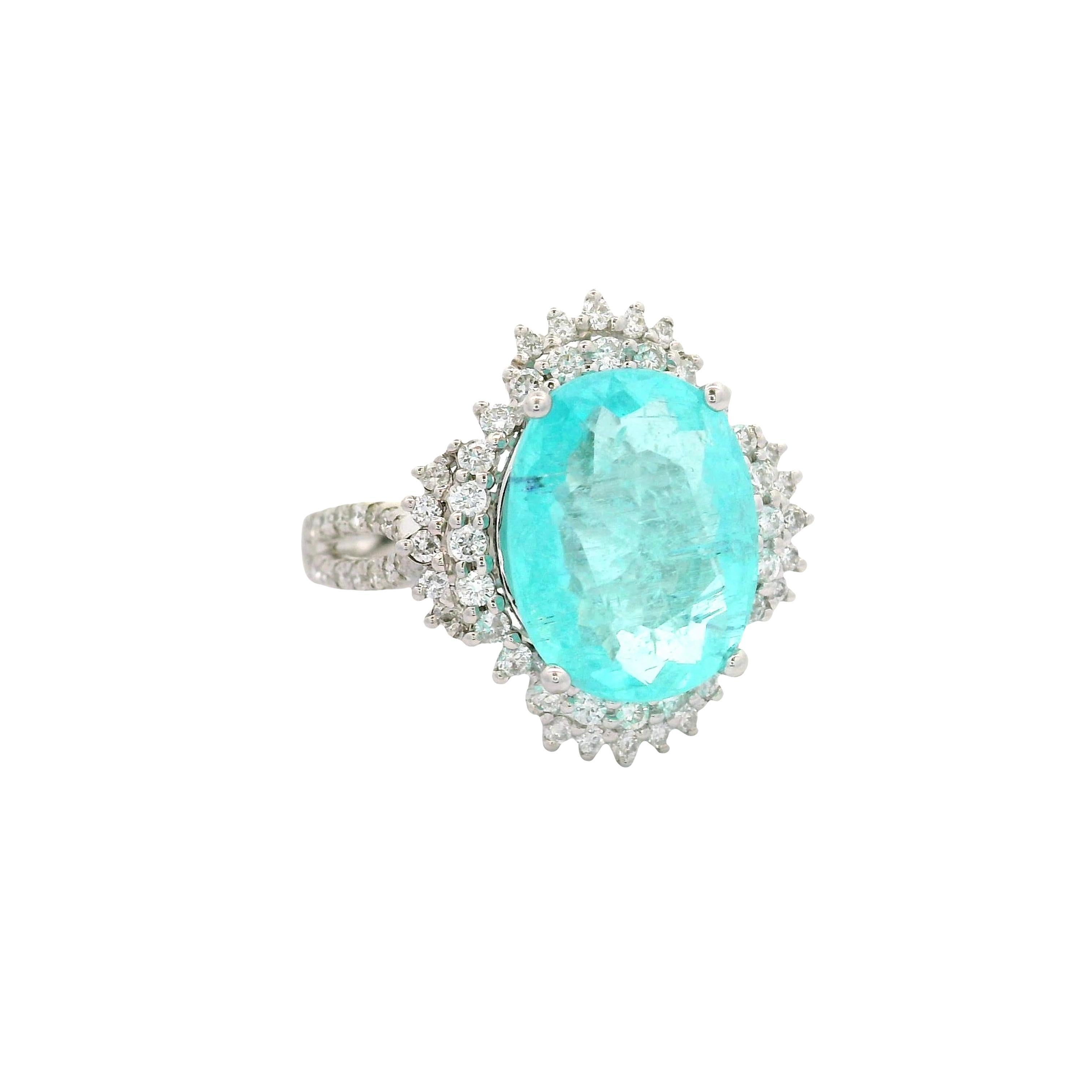 Une allure saisissante. Cette bague de cocktail met en valeur une tourmaline Paraiba ovale de 4,11 carats, d'un bleu verdâtre captivant. Il est entouré de 0,56 carats de diamants de taille ronde, offrant un éclat blanc éblouissant. Fabriquée en or