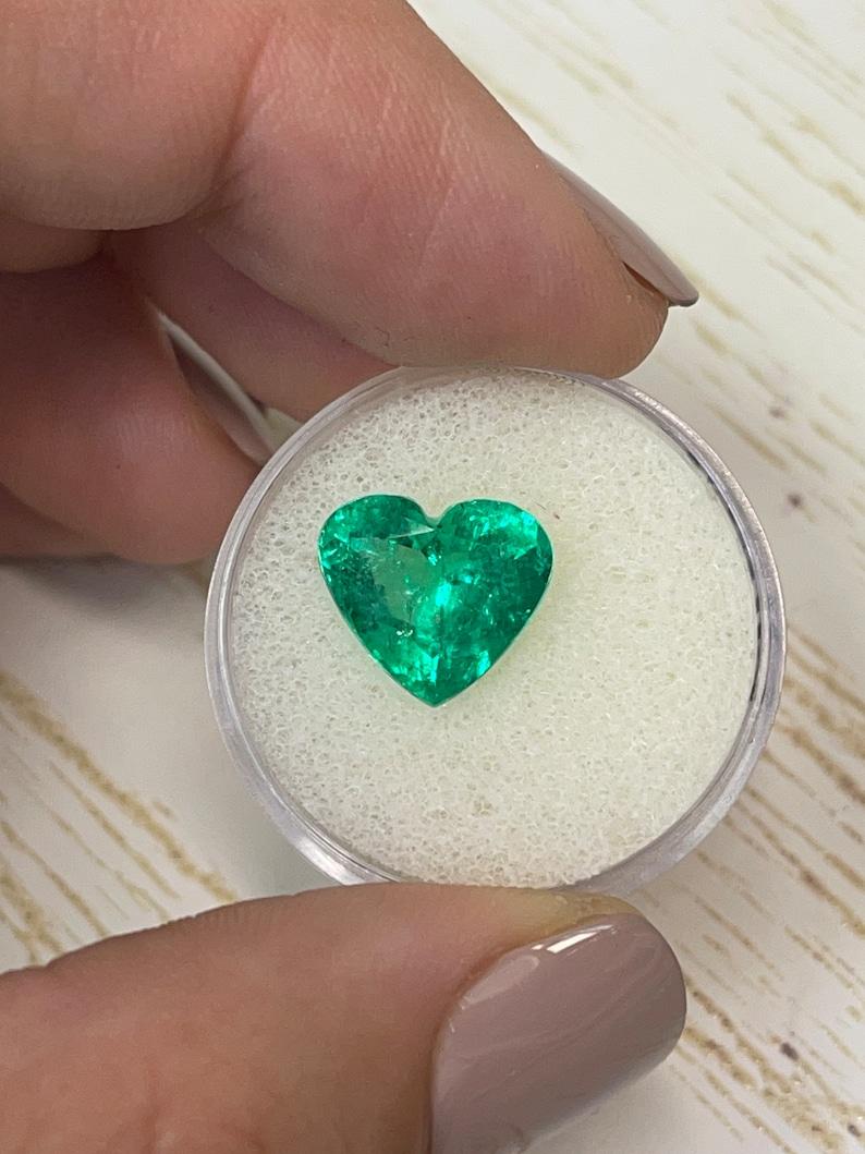 Stone: Emerald
Weight: 4.12-carats
Shape: Heart Cut
Clarity: Transparent
Luster: Excellent/Very Good
Color: Vivid Green
Measurements: 10.65mm x 11.91mm x 6.62mm
Geographic Origin: Colombia
Treatment: Natural, Minor Oil

Comments: Due to their growth