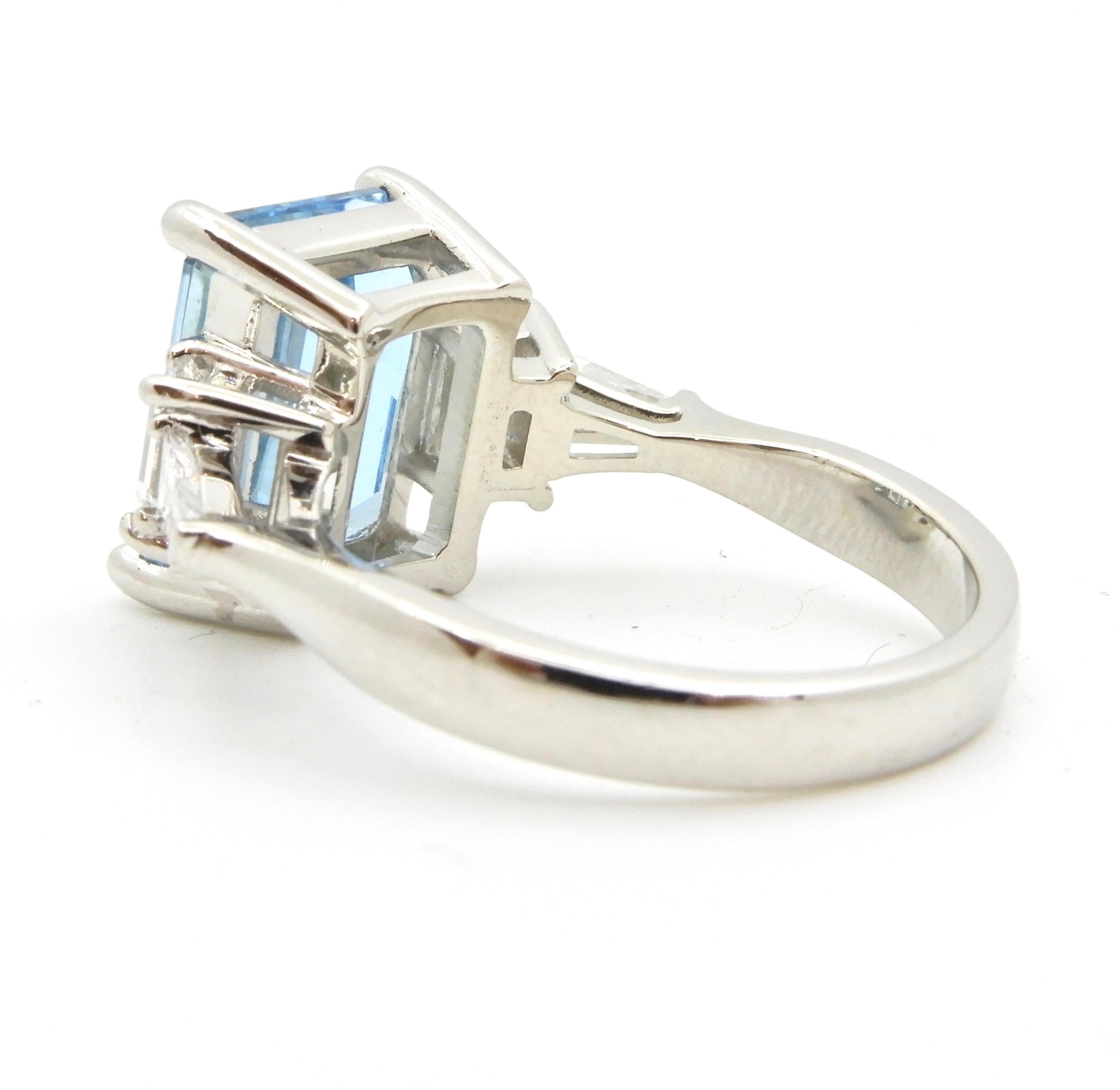 Your search for the ultimate Aquamarine ring is over. This 4.13 Carat Emerald Cut Aquamarine and Diamond Platinum Engagement Ring ticks all the boxes. It has a rounded, flat edge band with rising shoulders each with two split galleries and hold one