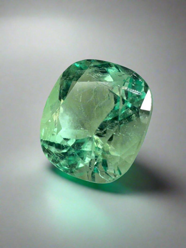 Stone: Emerald
Weight: 4.13-carats
Shape: Cushion Cut
Clarity: Transparent
Luster: Very Good
Color: Pastel Yellowish Green
Measurements: 10.35mm x 9.27mm x 7.41mm
Geographic Origin: Colombia
Treatment: Natural, Oiling

Comments: Due to their growth