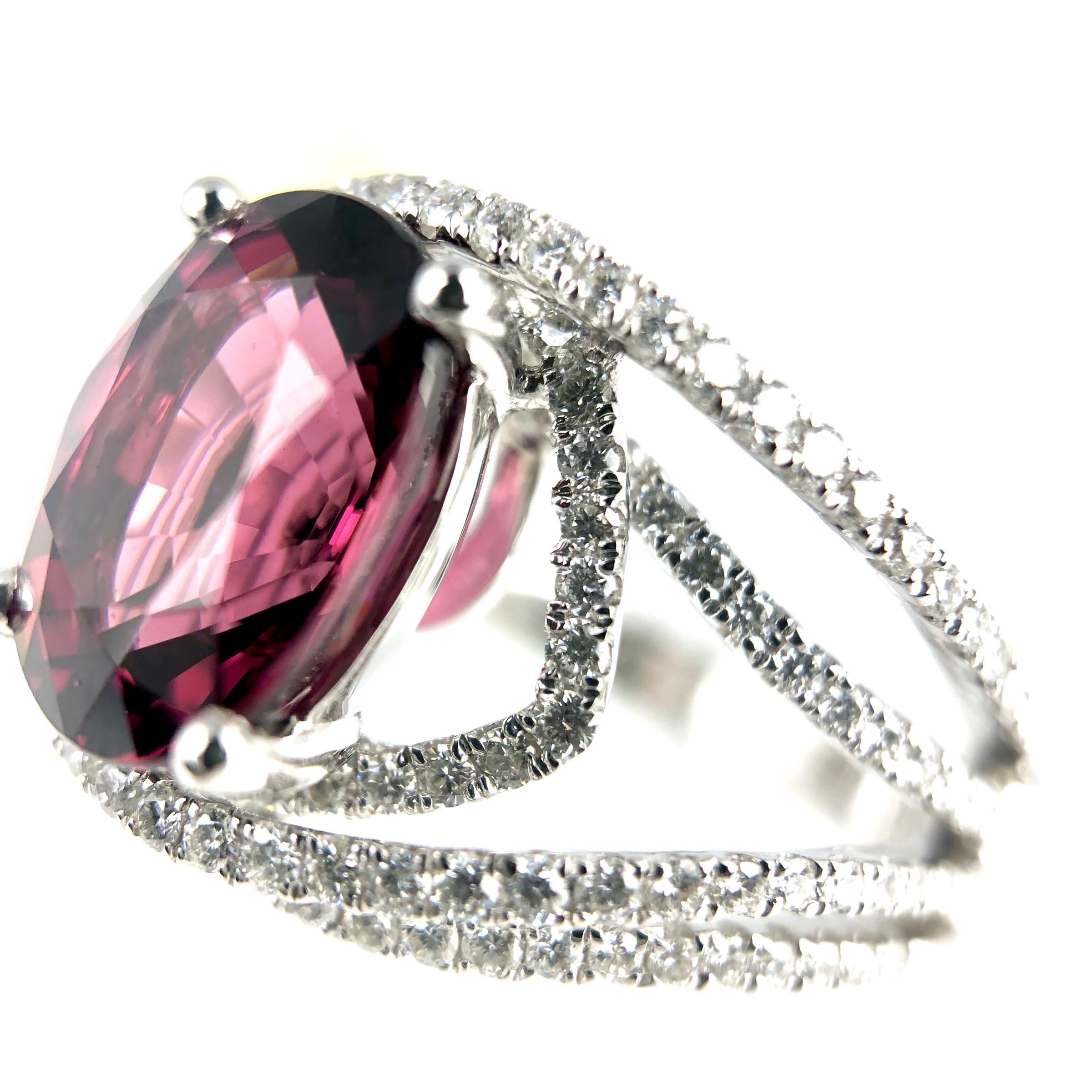 (DiamondTown) This gorgeous fashion ring has a 4.14 carat Oval Cut Raspberry Garnet center, atop intersecting layers of white diamonds. Total diamond weight 0.75 carats.

Ring size 6.5 with room to size up or down.
Set in 18k White Gold.

Many of