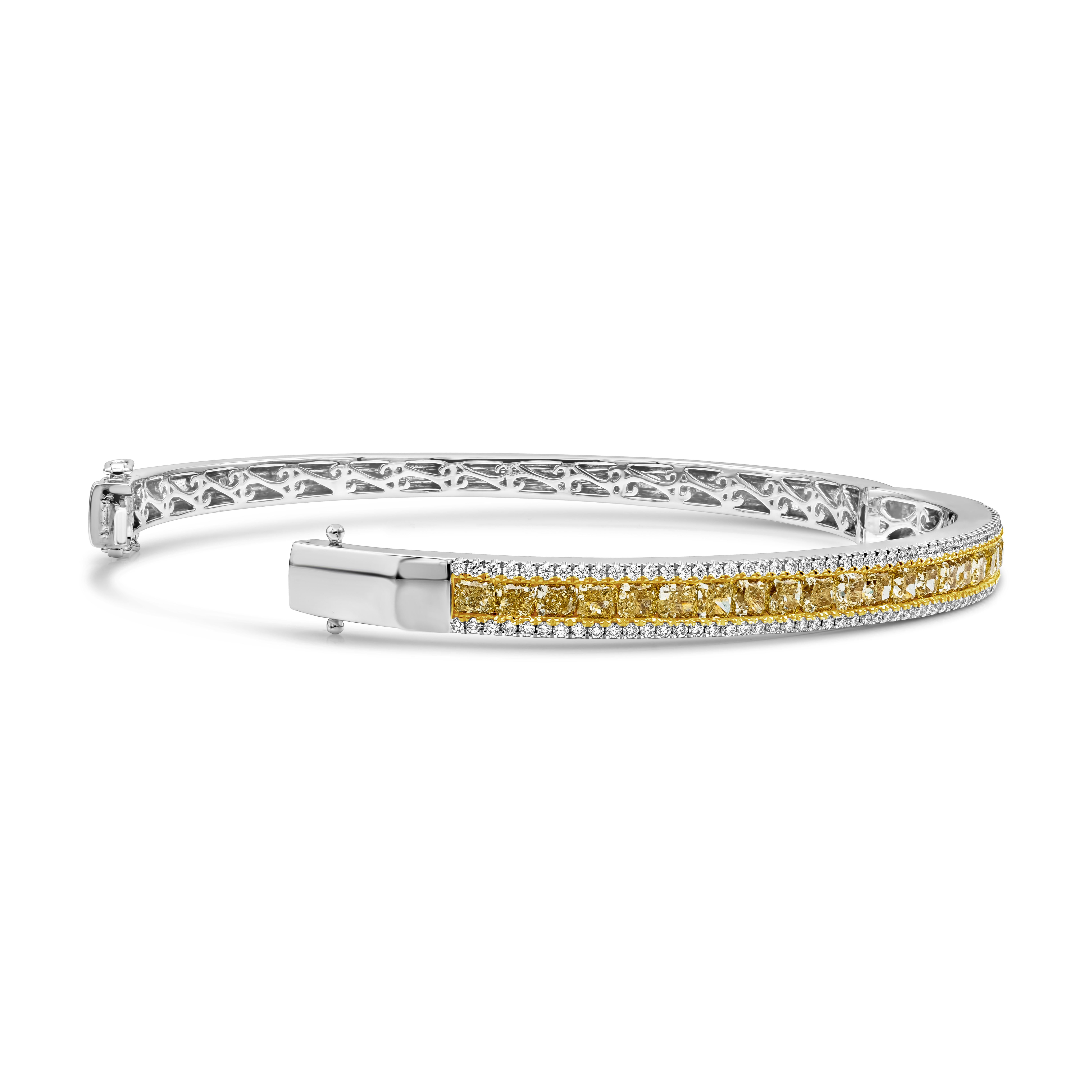 This chic-style bangle features a row of fancy yellow color cushion cut diamonds, weighs 4.14 carats total. Each 23 pieces of cushion cut diamonds is accented by a single row of round brilliant diamonds weighing 0.72 carats total. Fancy yellow color