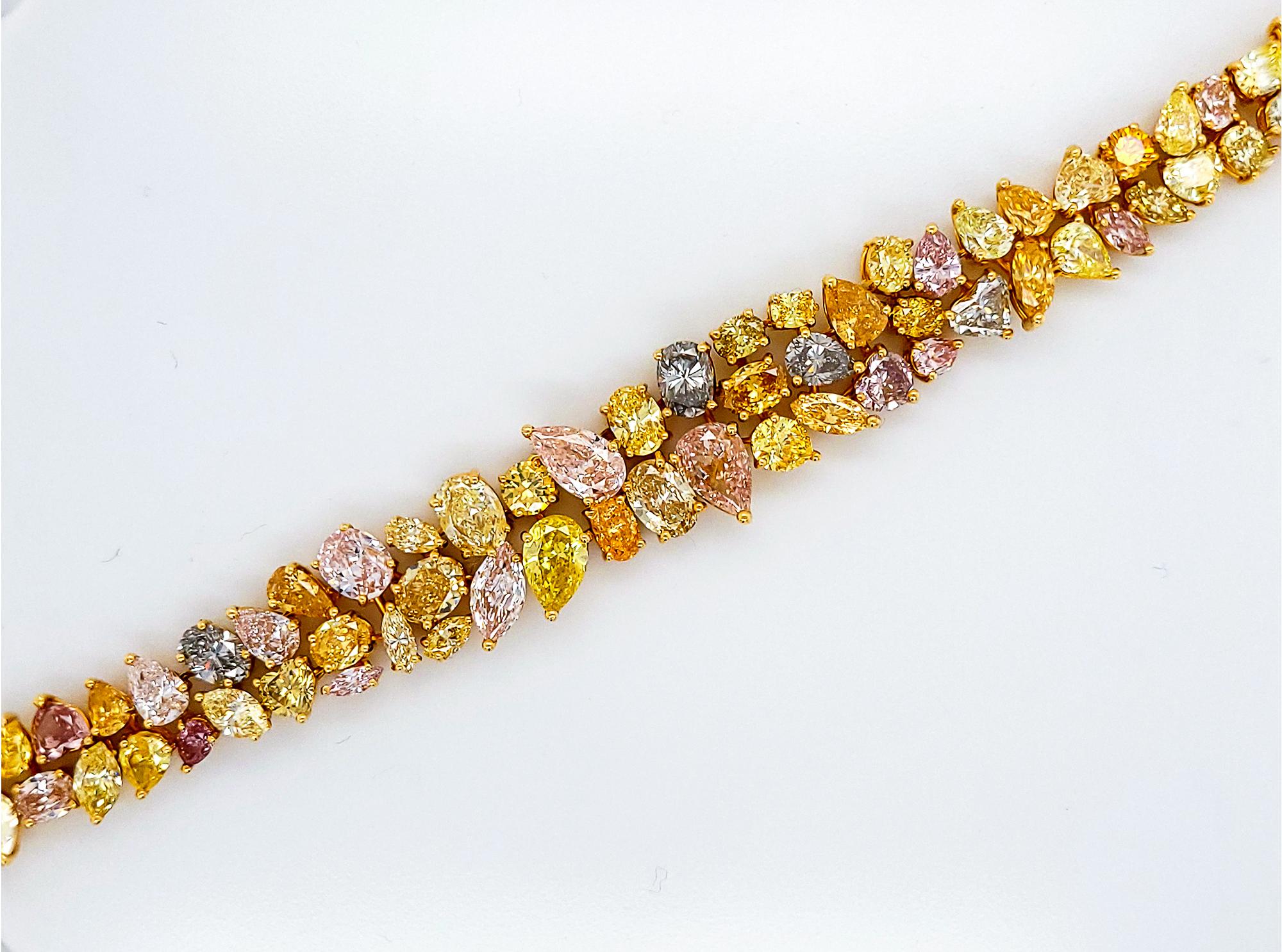 A stunning bracelet made in 18k yellow gold and is set with mixed cut fancy colored diamonds. 
Different range of hues from yellow, gray, blue, pink, purple, and orange. 
The 80 mixed-shape diamonds weigh a total of approximately 41.50 carats.