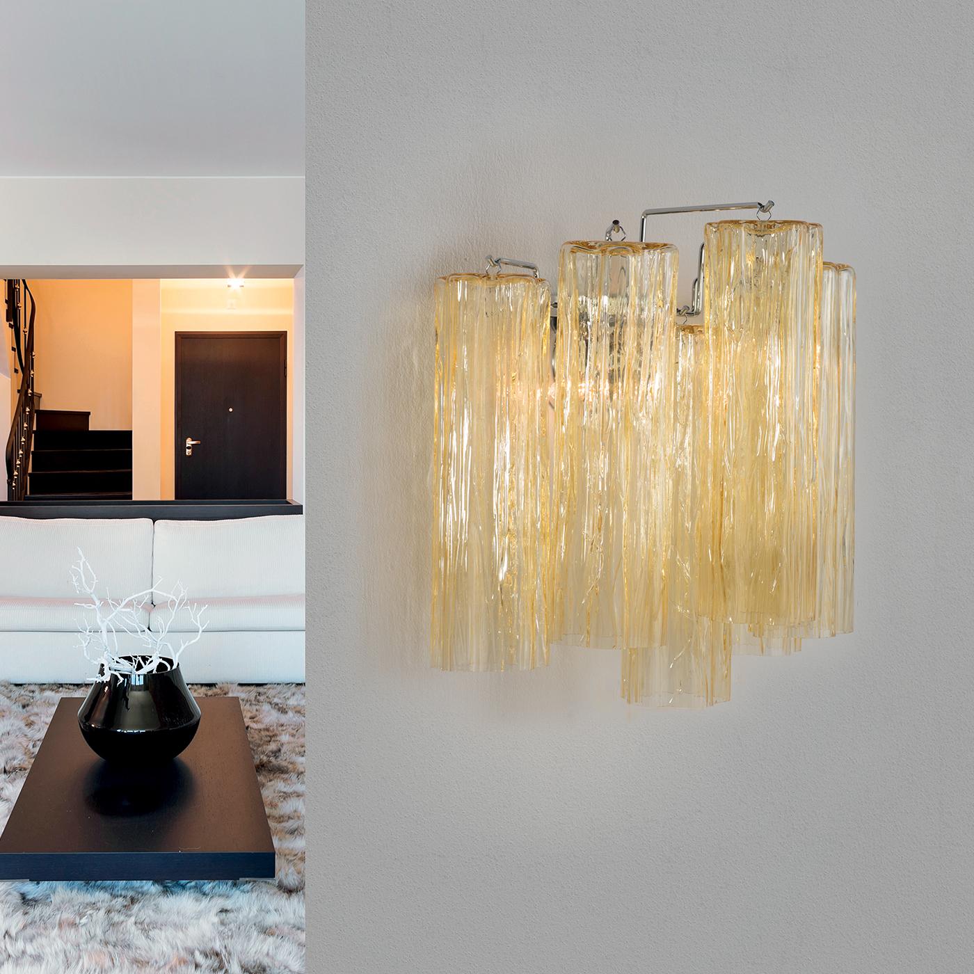Crafted in clear hammered glass with the main structure in a chrome or 24-karat gold finish, this beautiful lighting fixture features an amazing and luxurious design of hollow tubes in varying lengths cascading down. This incredible Wall Lamp offers