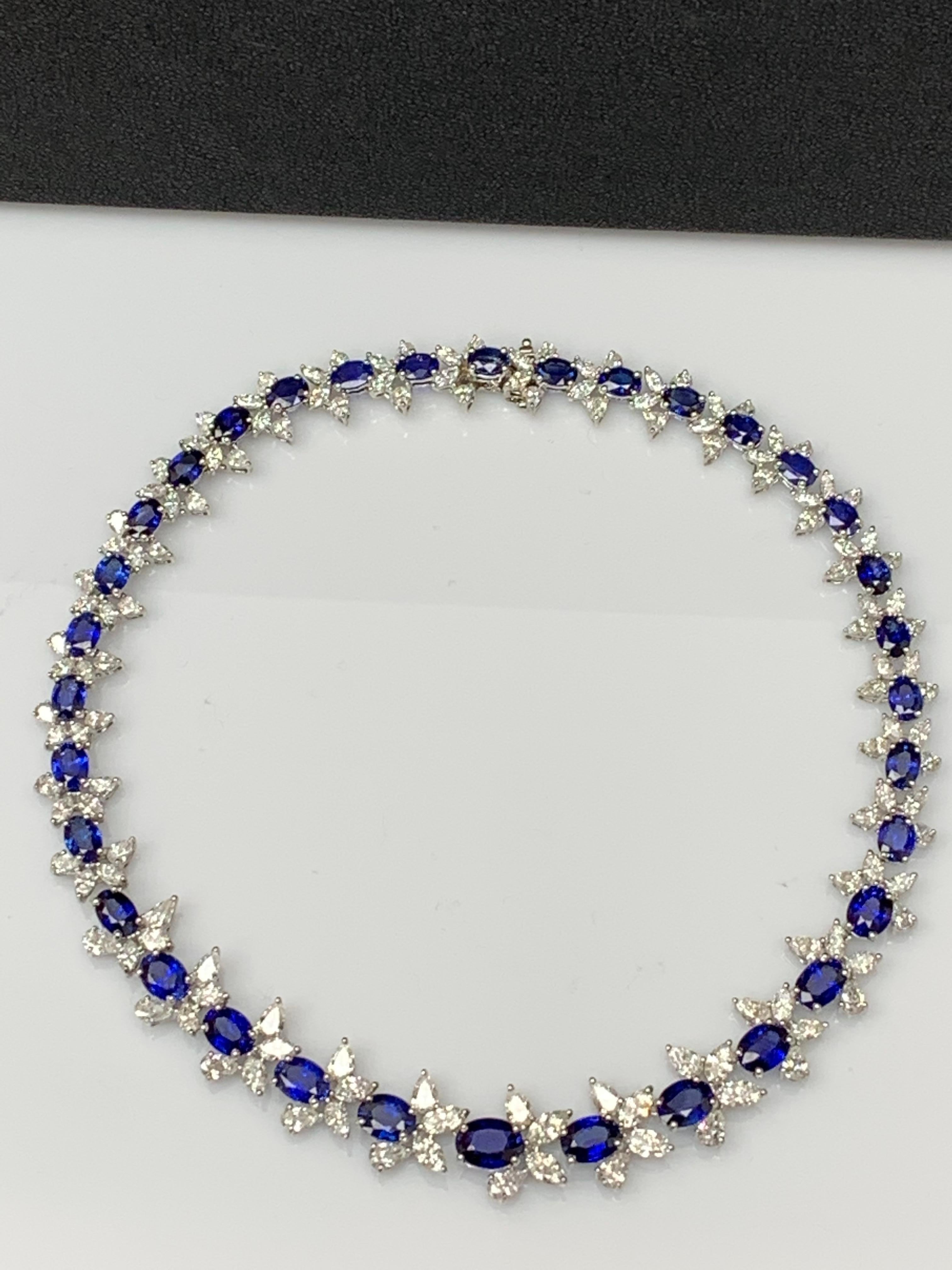 An important and very rare necklace showcasing vibrant and color-rich oval cut blue sapphires, set in a beautiful design. An intricately-designed necklace accented with brilliant mixed cut diamonds in a platinum mounting. 34 Blue Sapphires weigh