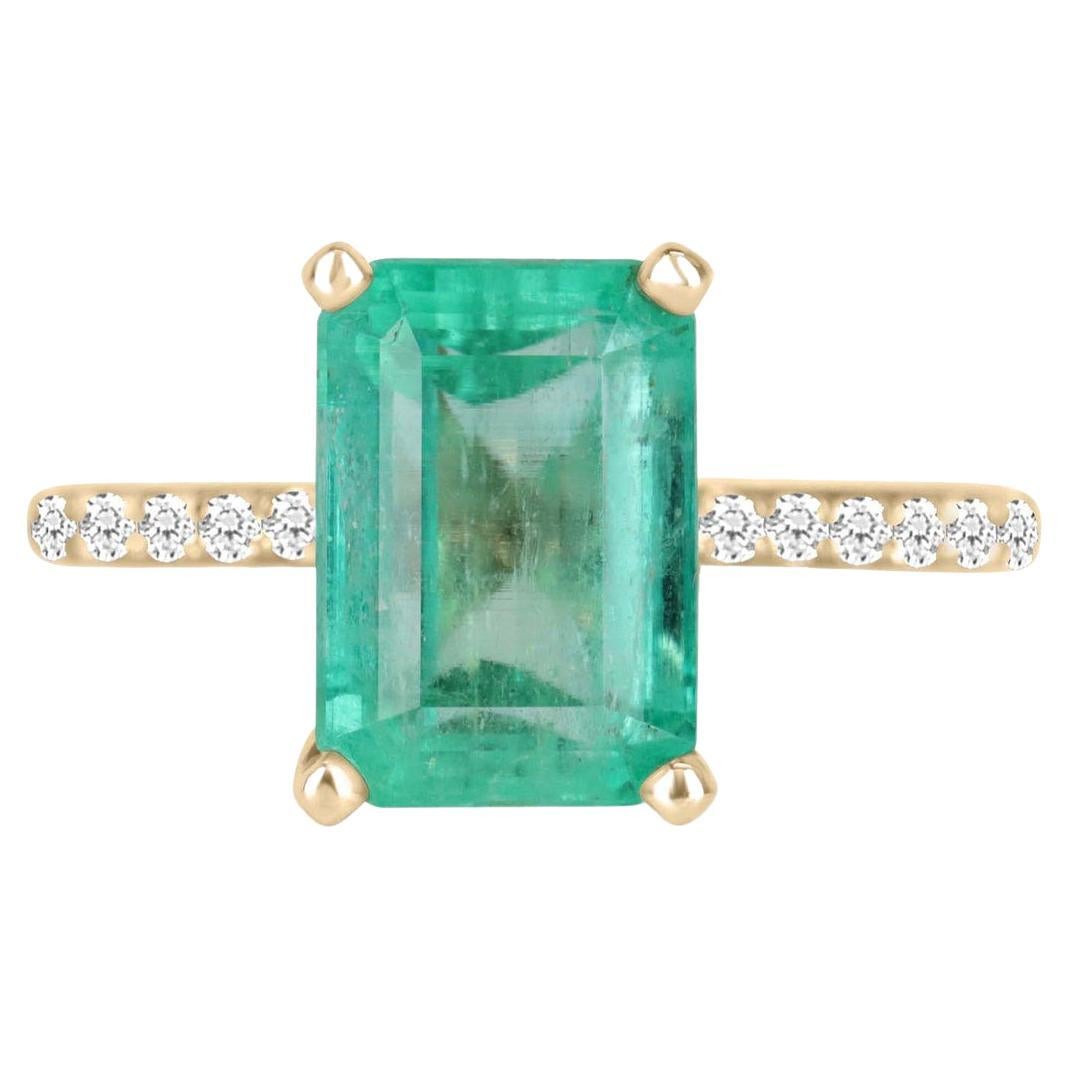 Elegantly displayed is a natural, emerald-cut Colombian emerald and diamond accent engagement ring. The center gem is a natural Colombian emerald filled with life and brilliance! Among the emeralds, impressive qualities are its vibrant color and