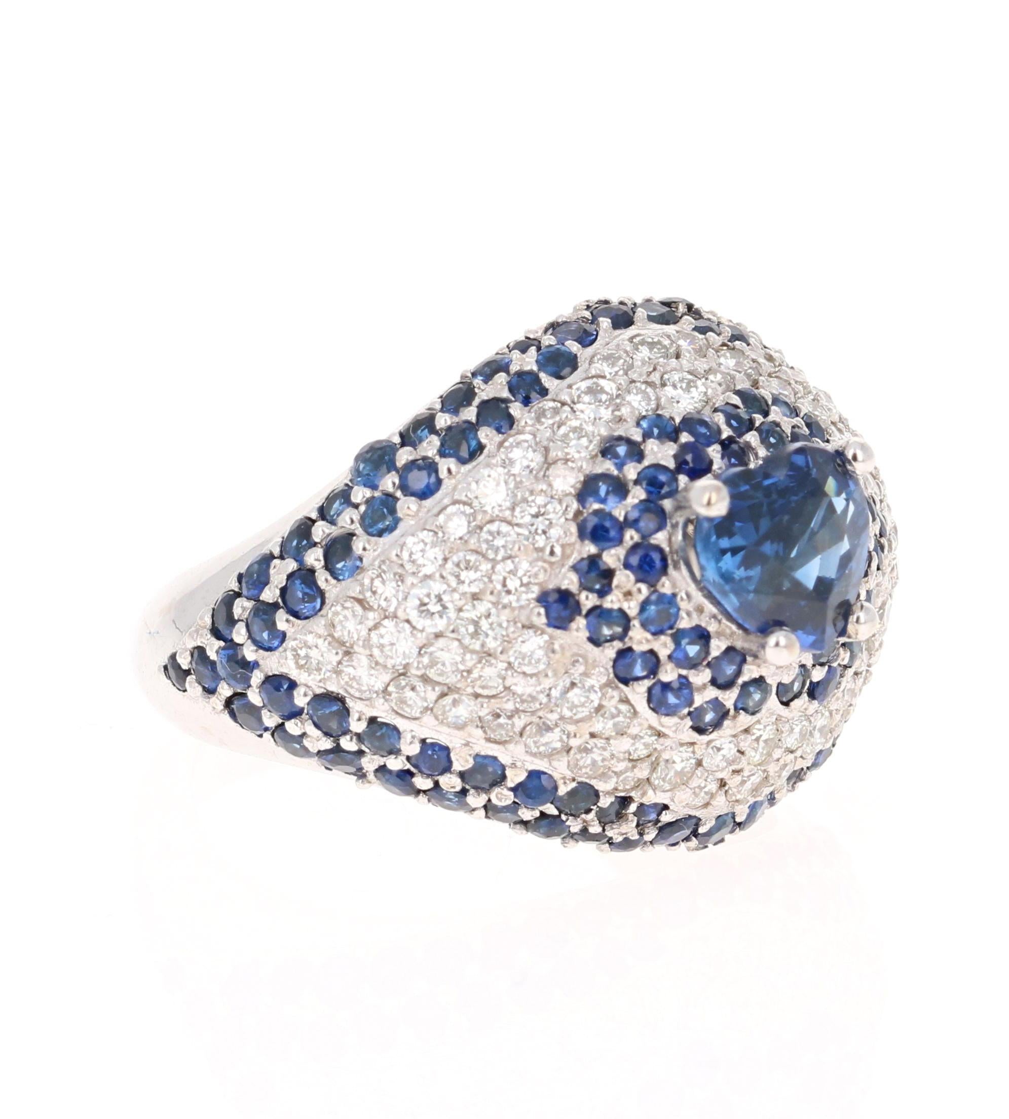 This beautiful blue sapphire ring has a Heart Cut 1.27 Carat Blue Sapphire and is surrounded by 130 Sapphires that weigh 1.95 Carats. It is further embellished with 78 Round Cut Diamonds that weigh 0.95 Carats. The total carat weight of the ring is