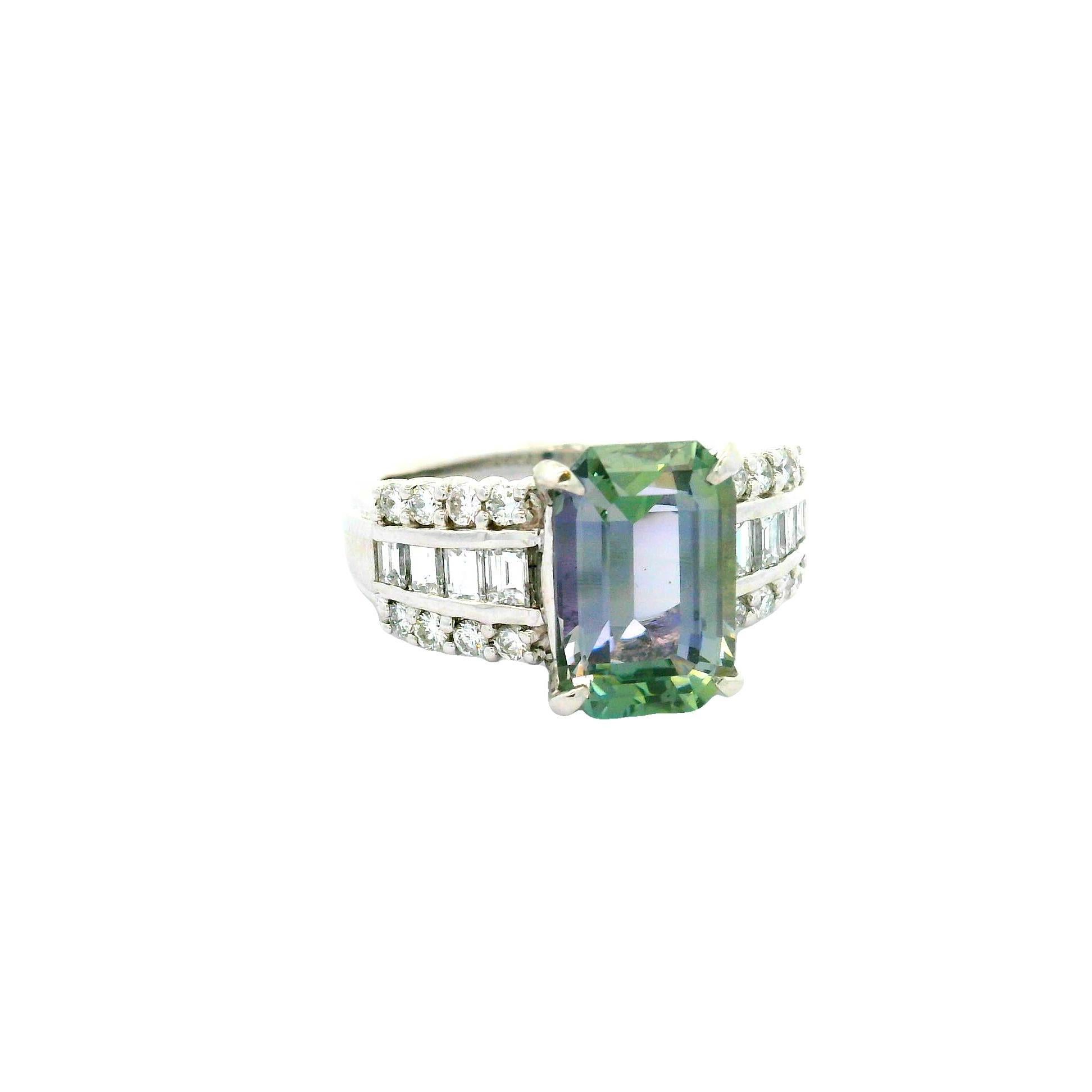 Ein auffälliger Tansanit mit einem Gewicht von 4,18 Karat ist der Mittelpunkt dieses modernen Rings. Der Stein im Smaragdschliff besticht durch seine Kombination aus violetten und grünen Farbtönen, die sofort ins Auge fallen. Der Tansanit wird von