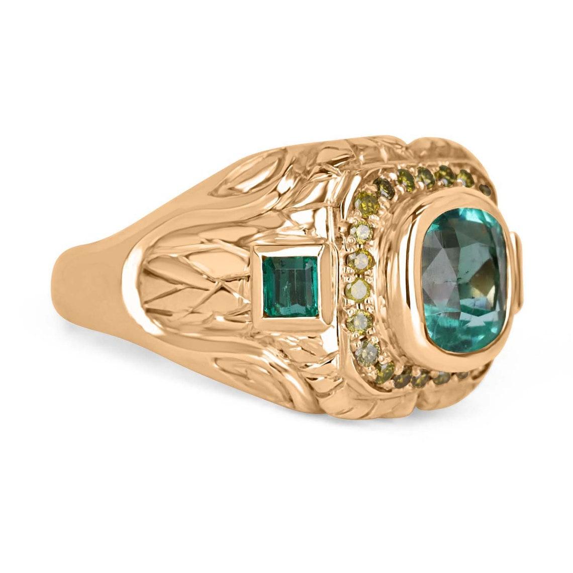 Setting Style: Men's Bezel-Set Rings
Setting Material: 14K Yellow Gold
Gold Weight: 15.5 grams

Main Stone: Colombian Emerald
Shape: Cushion - Square Cut
Approx Center Emerald: 3.14-Carats
Approx Accenting Emerald: 0.60-carats
Total Emeralds: 3
Eye