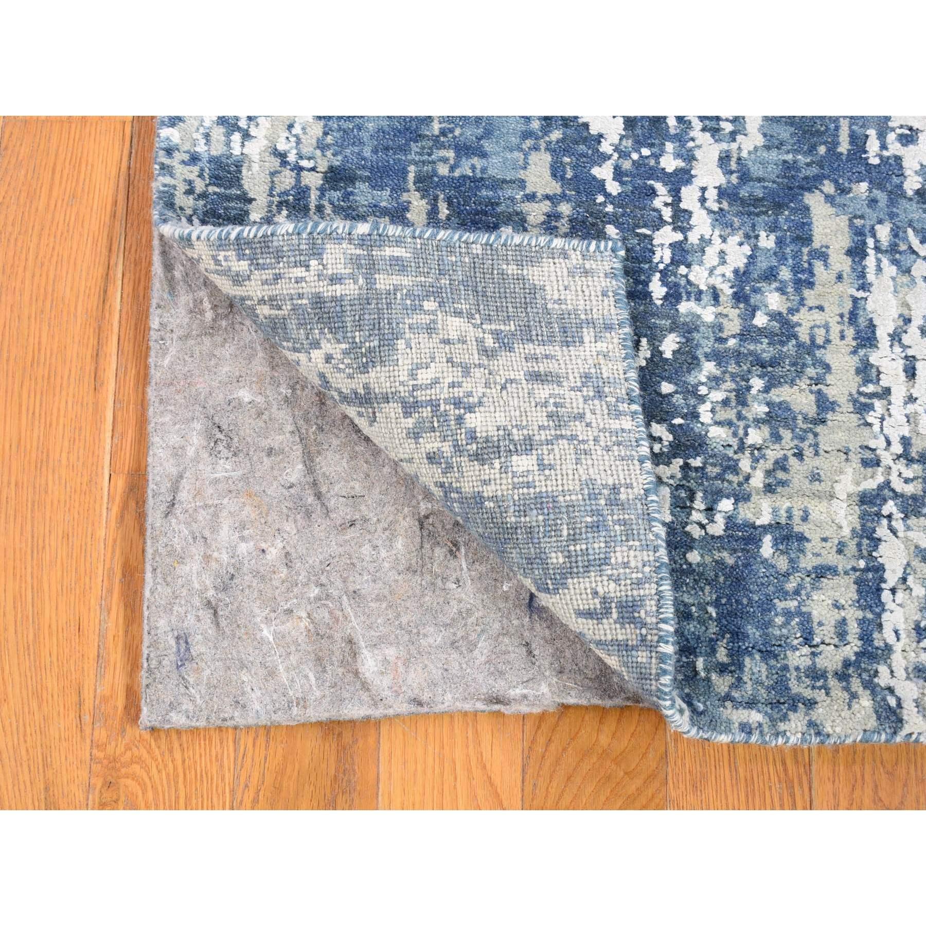 Il s'agit d'un véritable tapis de course oriental en laine et soie véritable, noué à la main, au motif abstrait bleu et aux couleurs douces. Il a été noué pendant des mois et des mois selon des techniques de tissage séculaires par des artisans