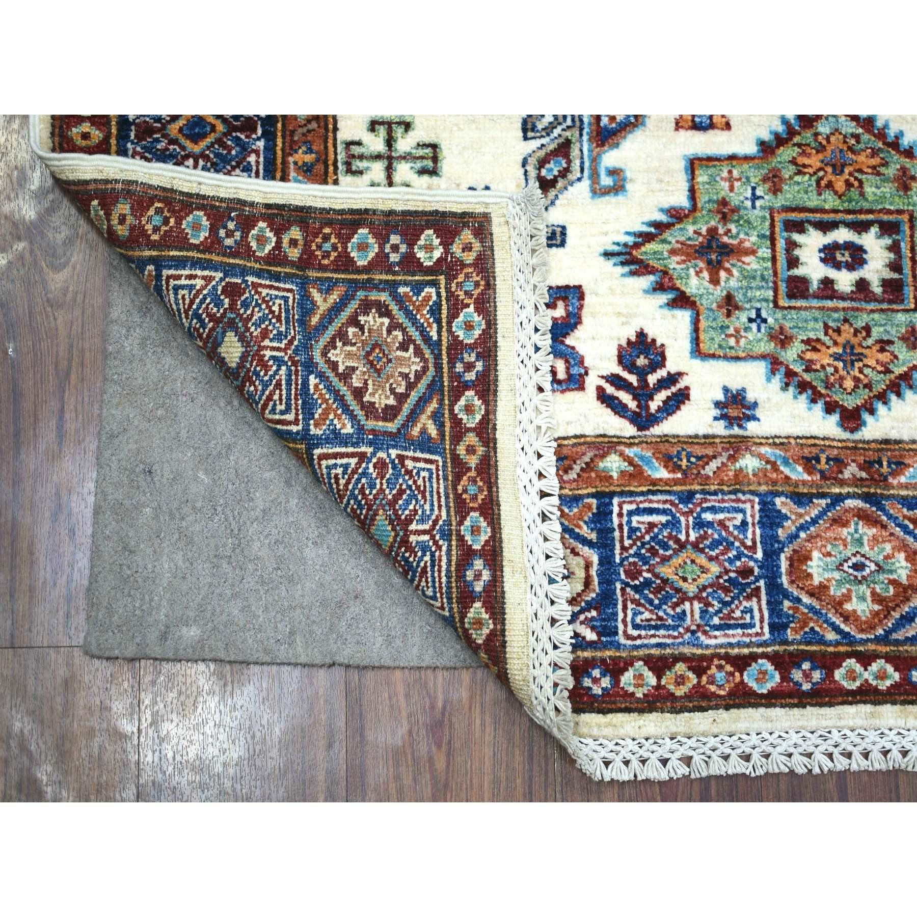 Il s'agit d'un véritable tapis d'Orient en ivoire, densément tissé en pure laine, noué à la main, teintures naturelles caucasiennes Super Kazak. Il a été noué pendant des mois et des mois selon des techniques de tissage séculaires par des artisans