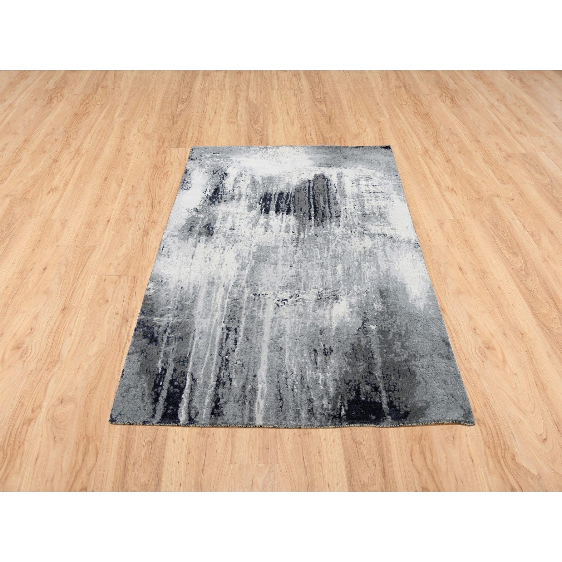 Il s'agit d'un véritable tapis oriental en laine et soie nouée à la main, unique en son genre, de couleur grise avec des touches d'ivoire au design abstrait. Il a été noué pendant des mois et des mois selon des techniques de tissage séculaires par