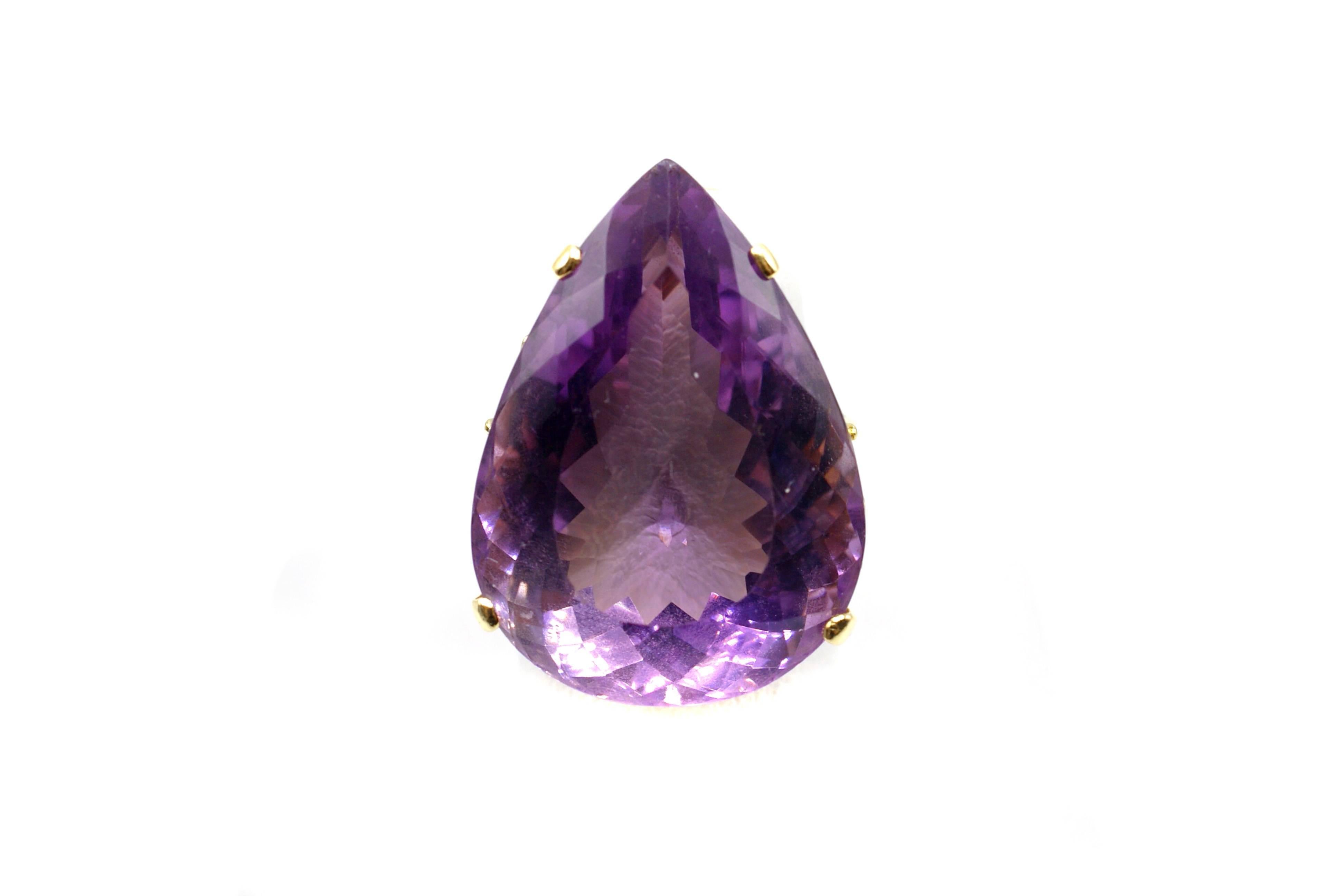 Impressive lovely lavender color Amethyst, measured to weigh approximately 42 carats is set in a custom designed and handcrafted 14 karat yellow gold mounting. This 1950s ring has 4 prongs safely holding the center stone and a pretty cup and gallery