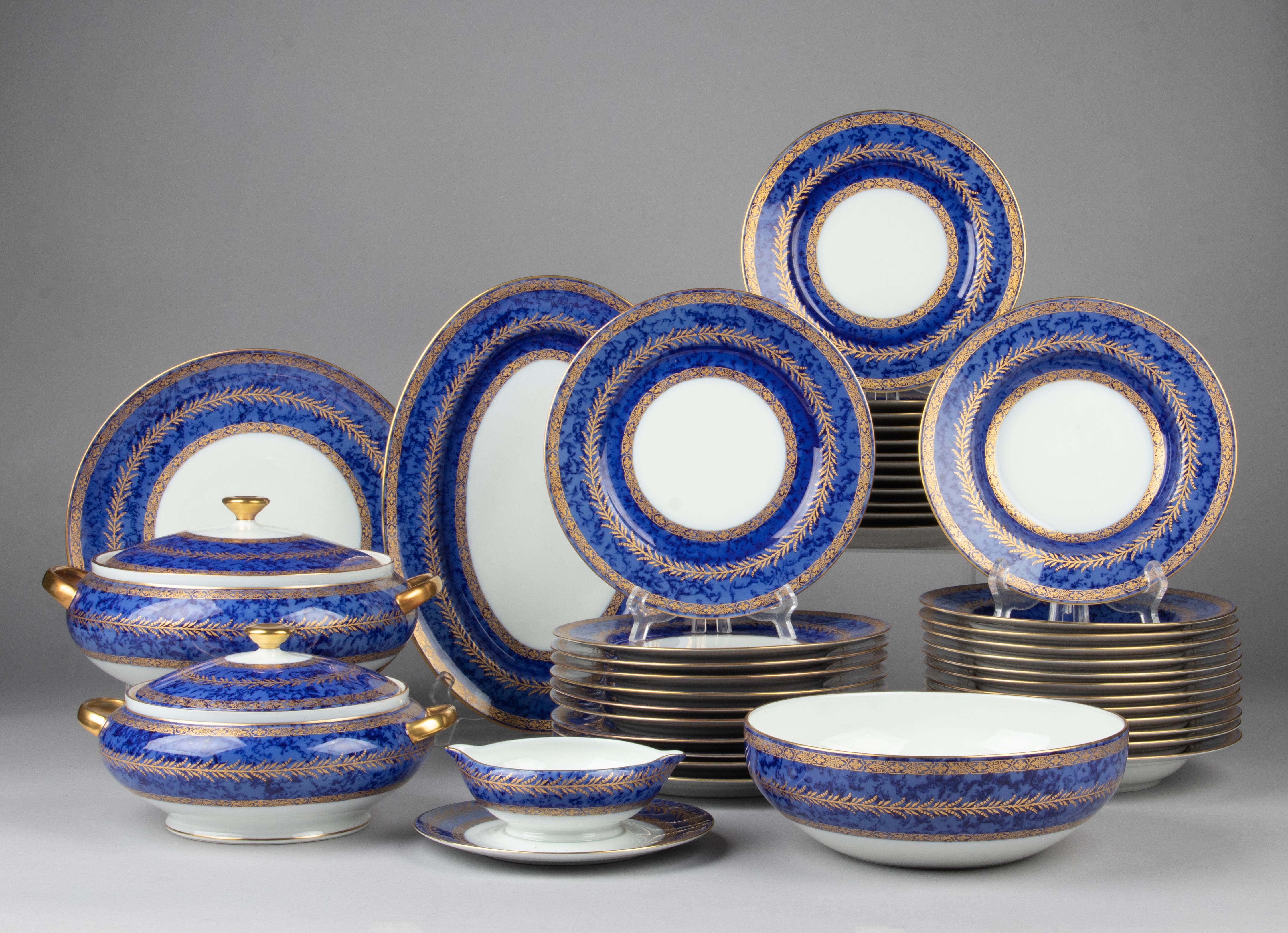 Beautiful set of porcelain tableware made by the French brand Raynaud Limoges. The porcelain has a deep blue color, with a kind of cloudy pattern, decorated with gold-coloured accents. The service is made by Raynaud Limoges. On the back of the