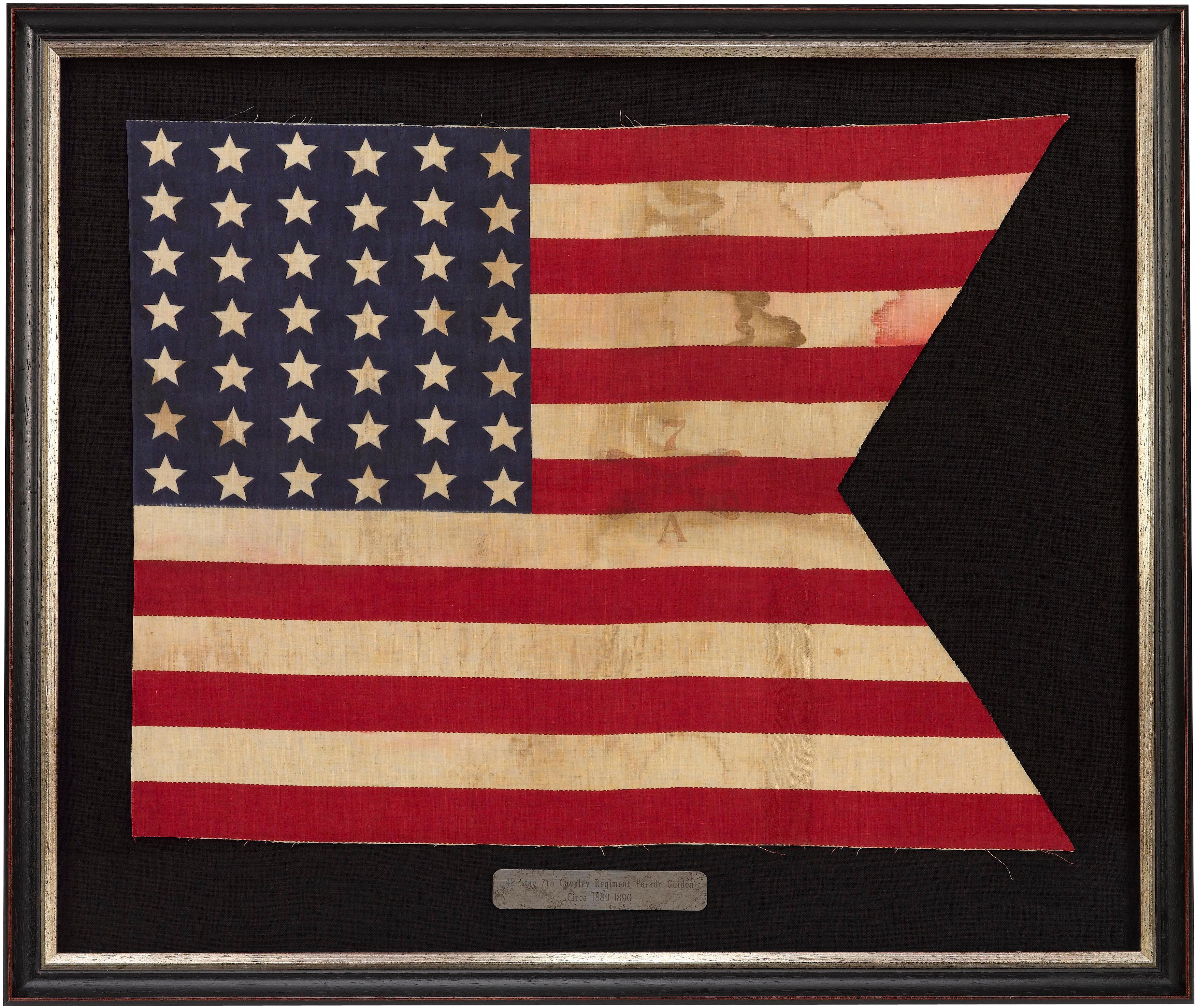 Presented is 42-star 7th Cavalry Regiment parade guidon, dating to 1889-1890. The guidon is printed in cotton, and stenciled over with a “7” over crossed swords of the 7th Cavalry Regiment. The flag also has a stenciled “A” indicating the specific