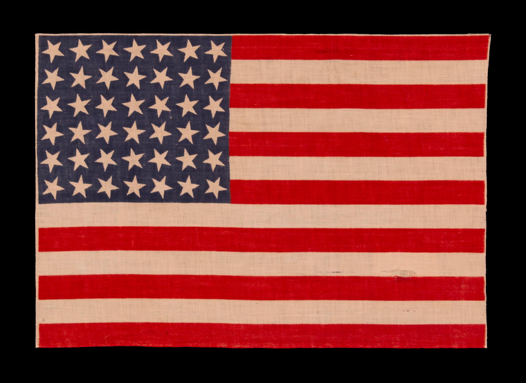 42 STARS ON AN ANTIQUE AMERICAN FLAG WITH SCATTERED STAR POSITIONING, REFLECTS THE ADDITION OF WASHINGTON STATE, MONTANA, AND THE DAKOTAS, NEVER AN OFFICIAL STAR COUNT, circa 1889-1890

42 star parade flag, printed on plain weave cotton. The stars