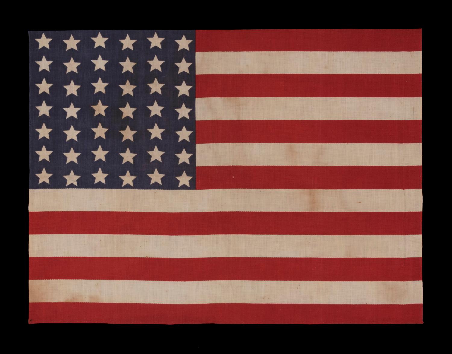 42 STARS IN A WAVE CONFIGURATION OF LINEAL COLUMNS, NEVER AN OFFICIAL STAR COUNT, 1889-1890, WASHINGTON STATEHOOD 

42 star American parade flag, printed on cotton. The stars are arranged in what is called a “wave” configuration. Note how these