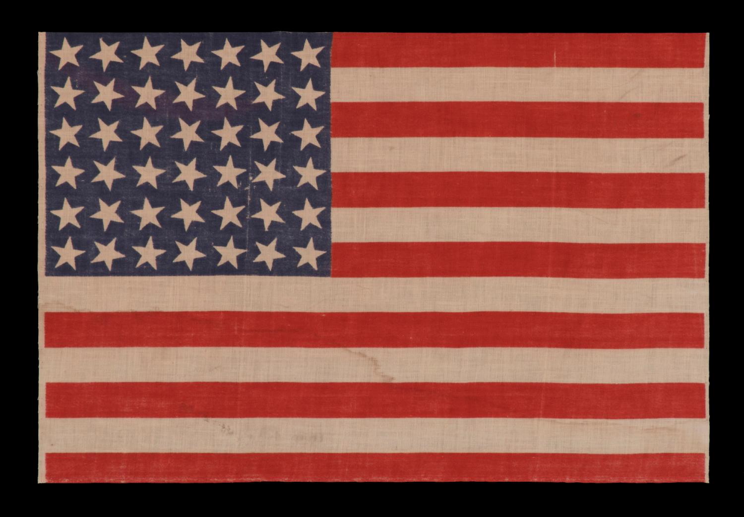 42 stars, an unofficial star count, on an antique American flag with scattered star positioning, 1889-1890, Washington Statehood

42 star parade flag, printed on cotton muslin. The stars are arranged in a rectilinear fashion, but vary in position