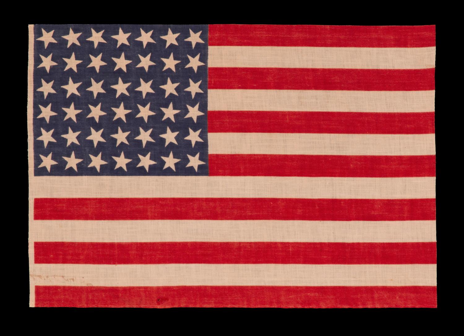 42 STARS, AN UNOFFICIAL STAR COUNT, ON AN ANTIQUE AMERICAN FLAG WITH SCATTERED STAR POSITIONING, 1889-1890, WASHINGTON STATEHOOD 

42 star parade flag, printed on cotton muslin. The stars are arranged in a rectilinear fashion, but vary in position