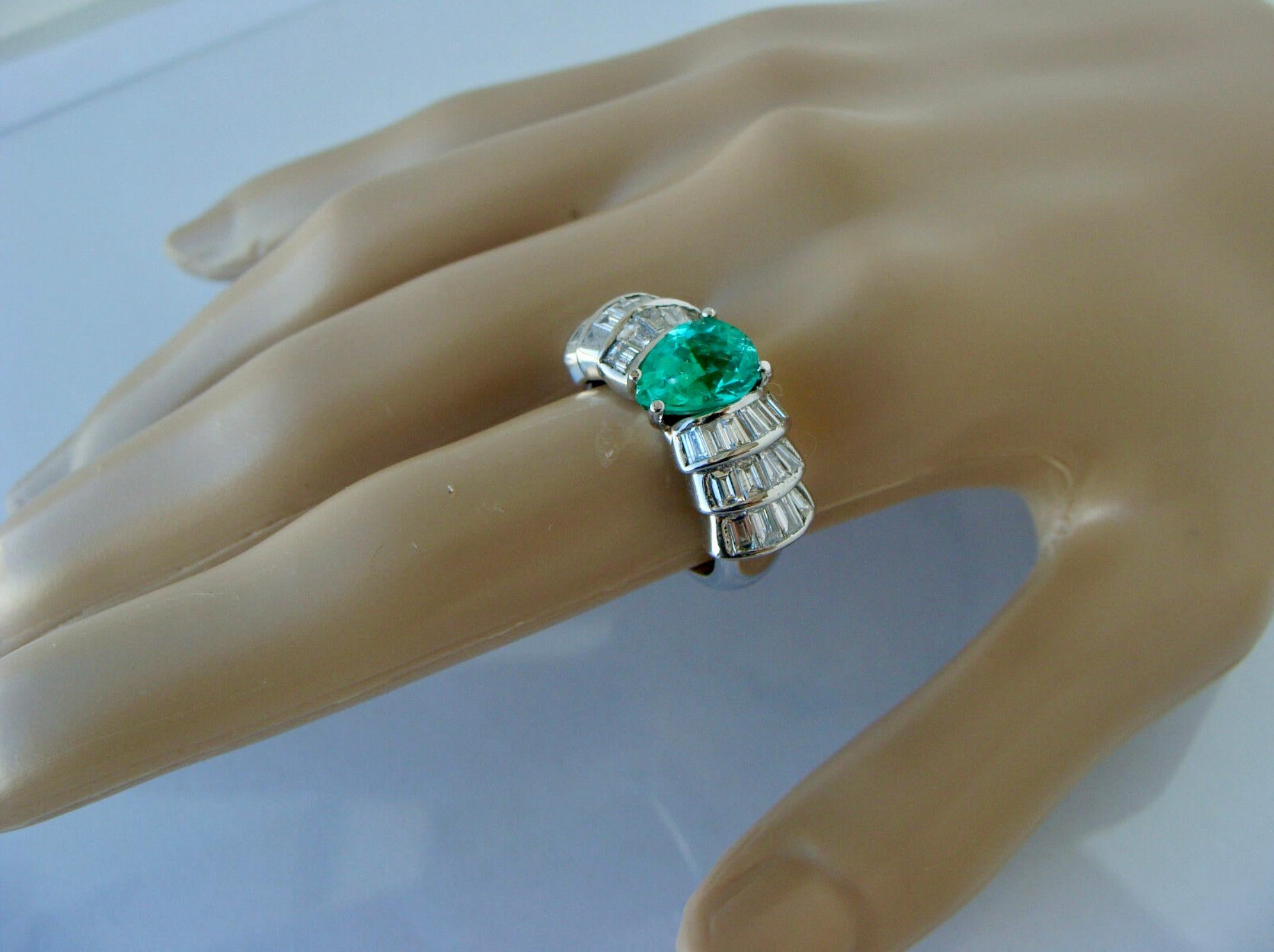 Colombian natural emerald and diamond estate ring. Centre set pear cut Colombian emerald flanked by baguette-cut diamonds in a white gold setting. The emerald is a beautiful fresh green colour and the diamonds are bright white and have a lively